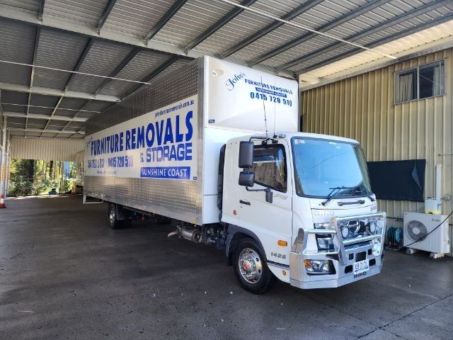 White Moving Truck Parked Under a Metal Awning — John's Furniture Removals in Beerwah, QLD