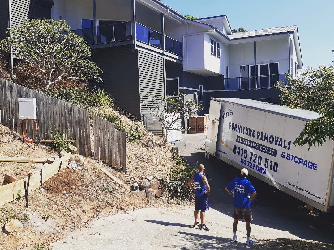 A Truck Parked on a Steep Driveway and Two Men Standing in Front of It — John's Furniture Removals in Sunshine Coast, QLD