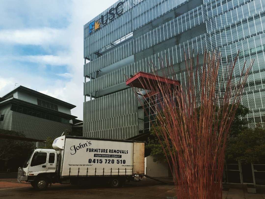 Truck Next to Modern Building — John's Furniture Removals in Yandina, QLD