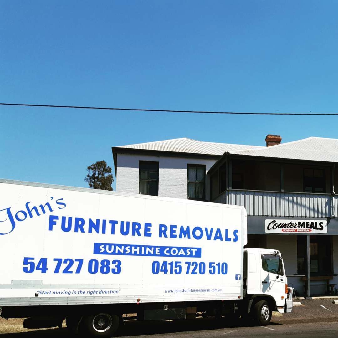 Moving Truck Parked in Front of a Building on a Sunny Day — John's Furniture Removals in Noosa Heads, QLD