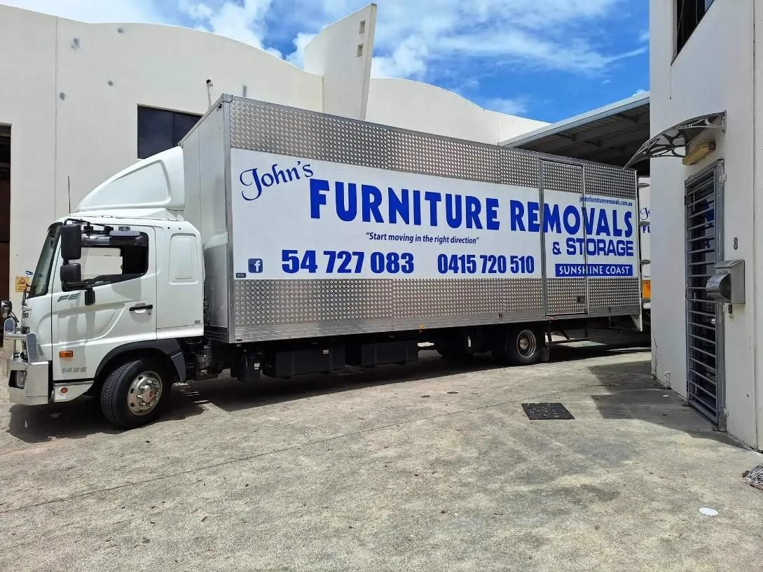 White Moving Truck Parked Outside a Building — John's Furniture Removals in Brisbane, QLD