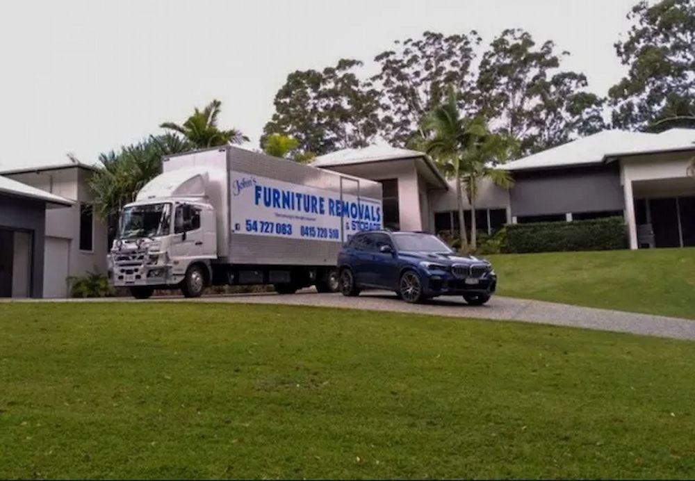Moving Truck Parked in Front of a House — John's Furniture Removals in Yandina, QLD
