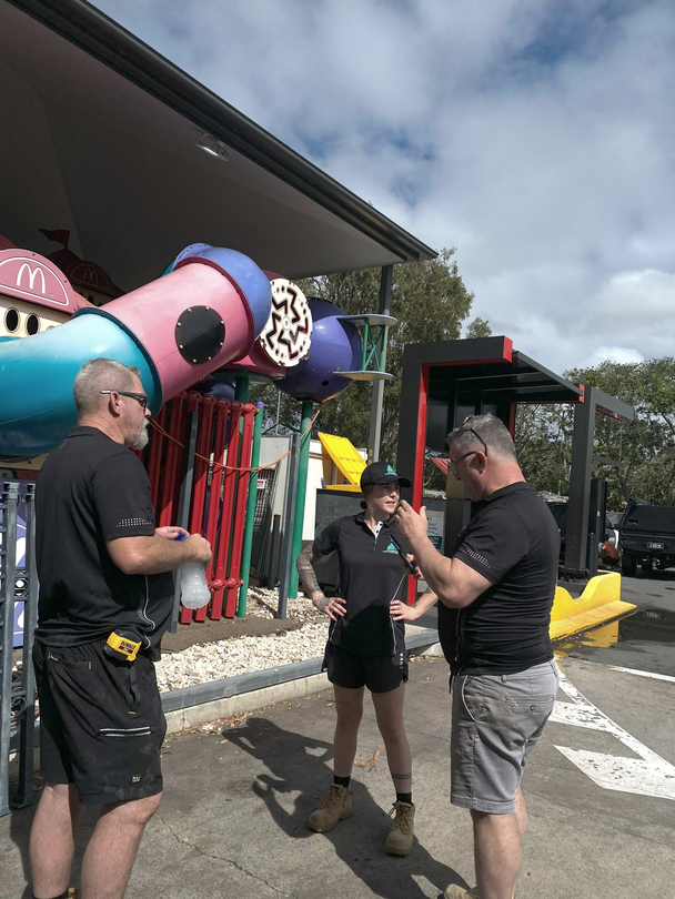 A man is cleaning the roof of a building with a high pressure washer.