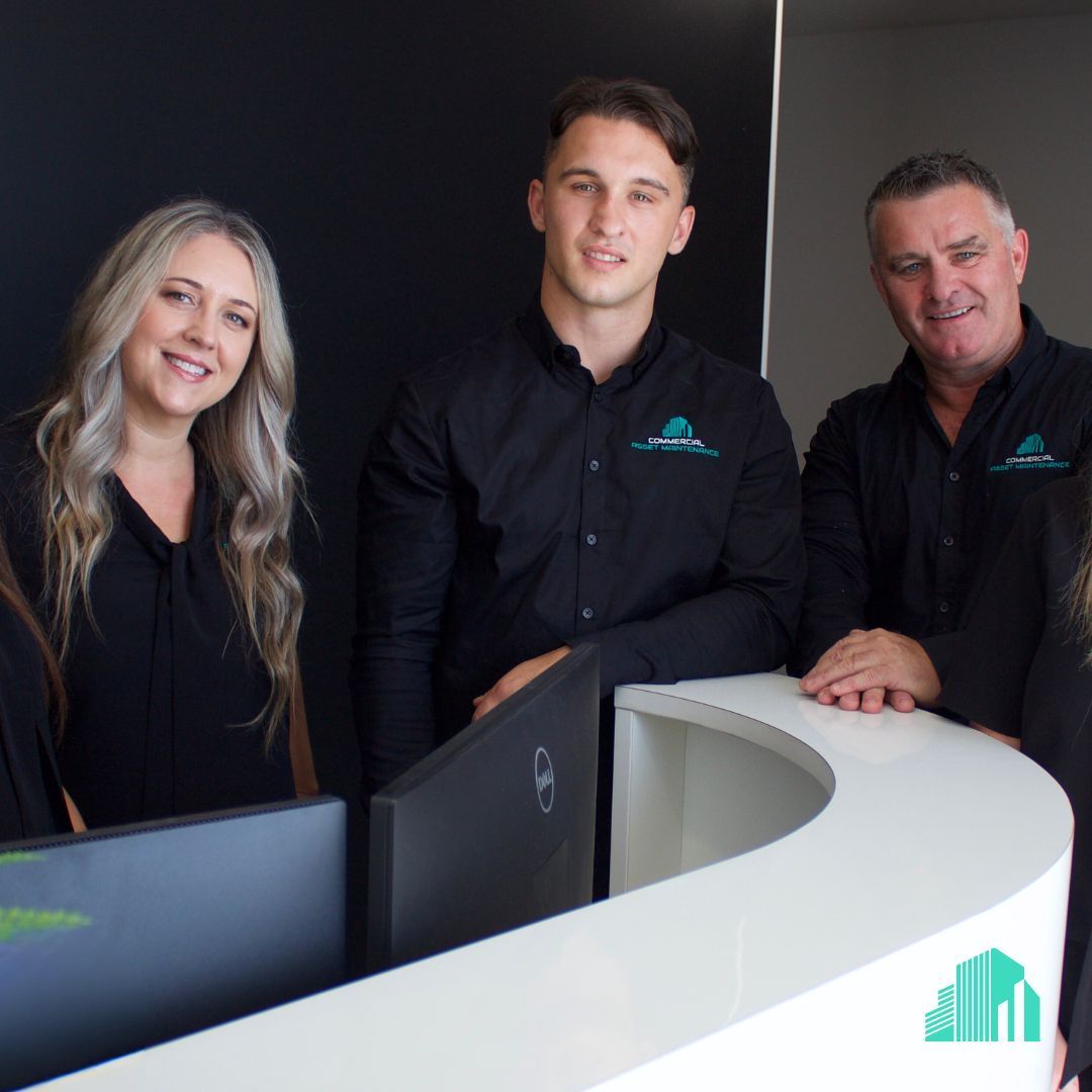 A Group of People Posing for a Picture in Front of a Computer — Commercial Asset Maintenance In Coolum Beach, QLD