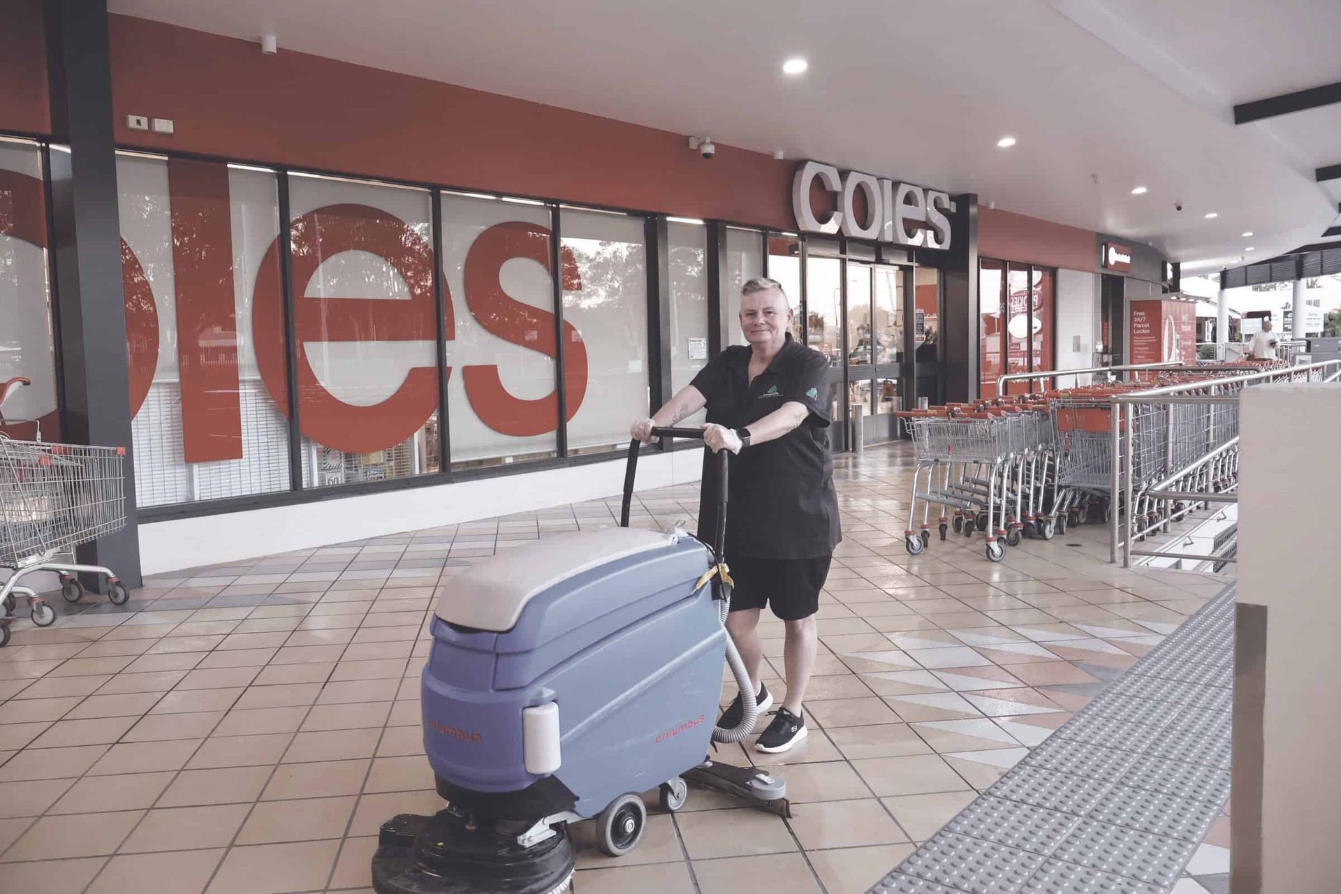 A Man is Cleaning the Floor of a Store With a Machine — Commercial Asset Maintenance In Mooloolaba, QLD