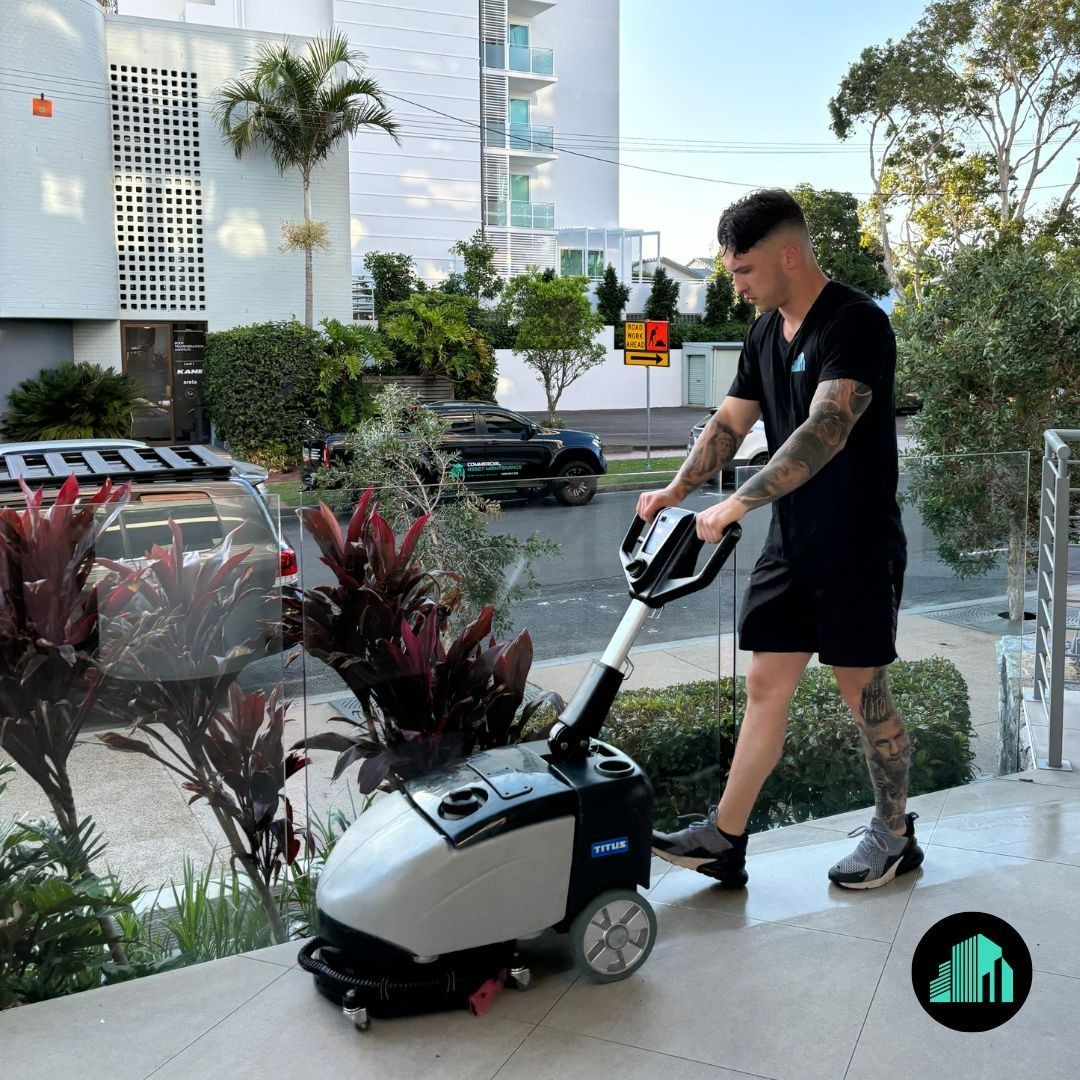 A Man Using Floor Cleaning Machine Outside a Building — Commercial Asset Maintenance In Strathpine, QLD