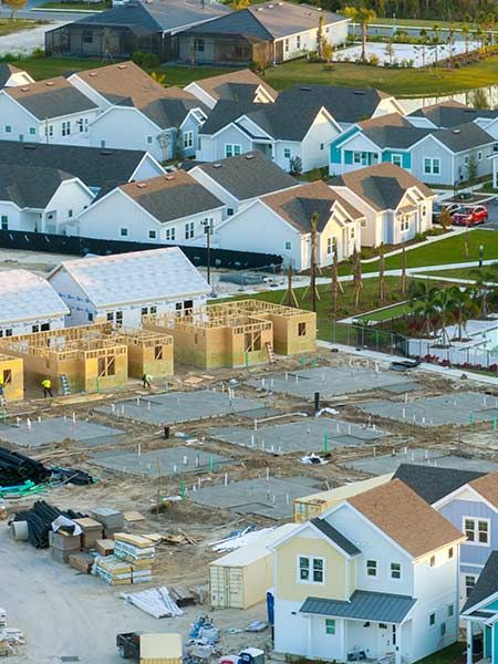 Suburban neighborhood with construction. New houses under construction, existing houses in various colors.