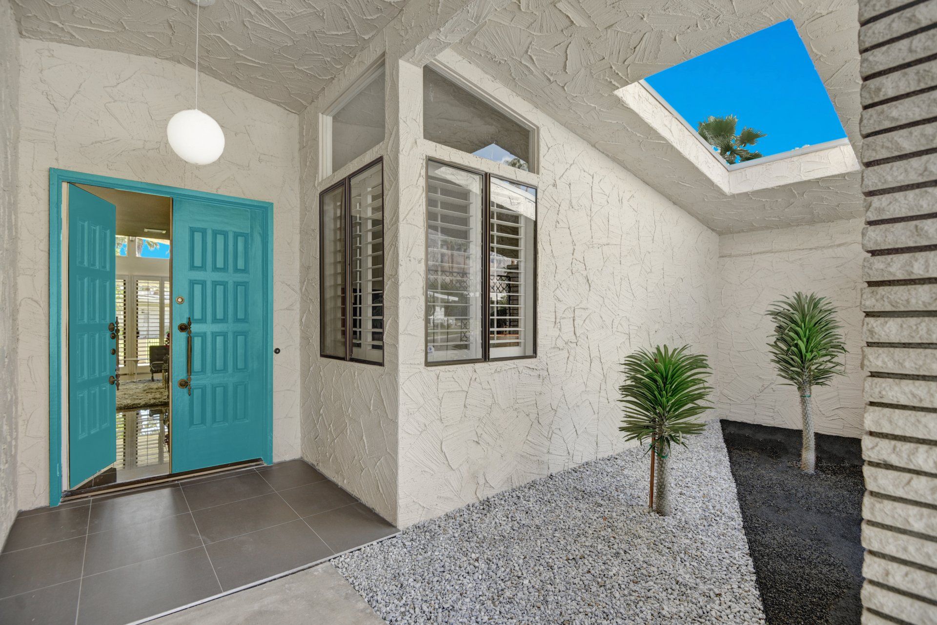 A house with a blue door and a skylight in the ceiling.