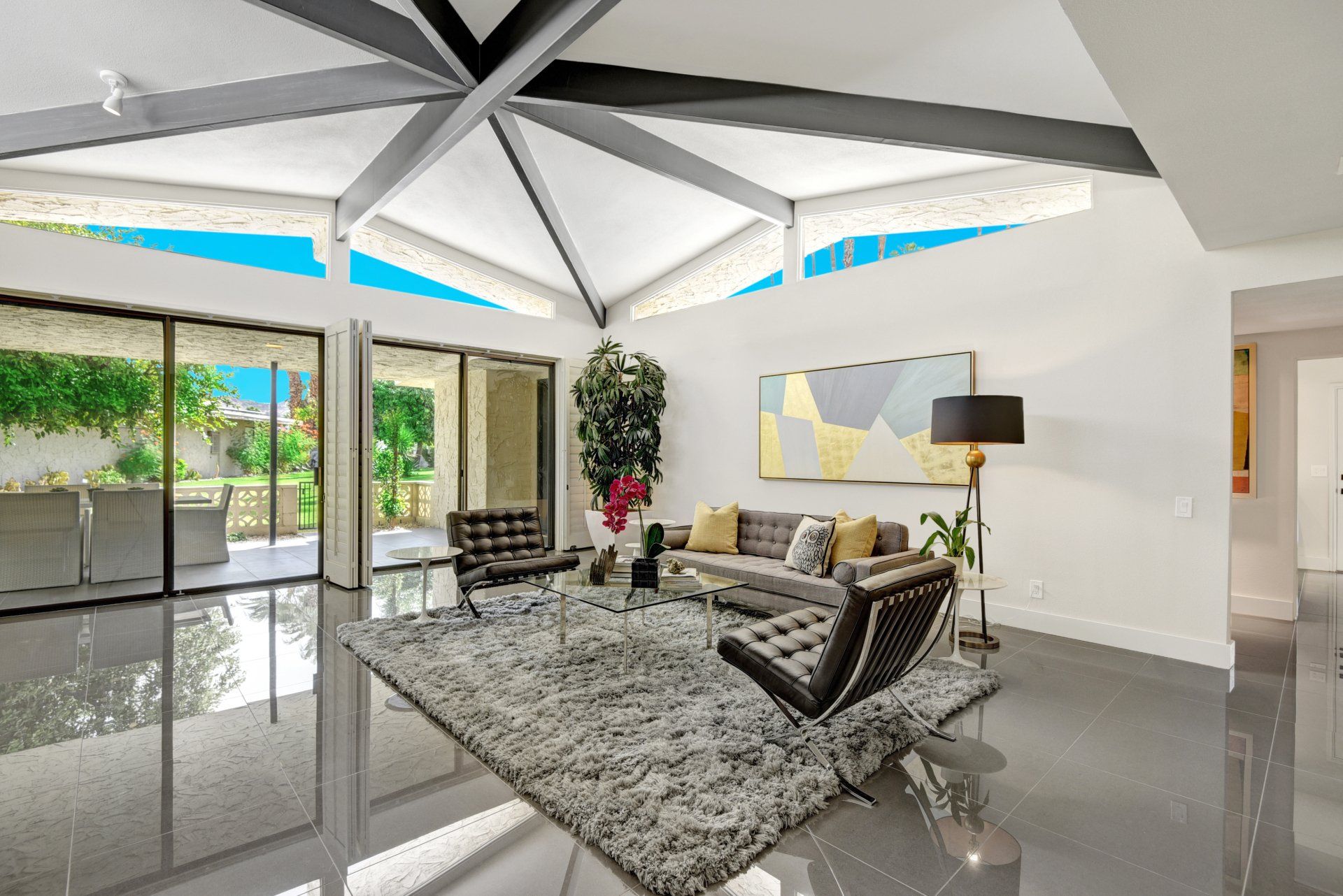 A living room with a couch , chairs , and a rug.
