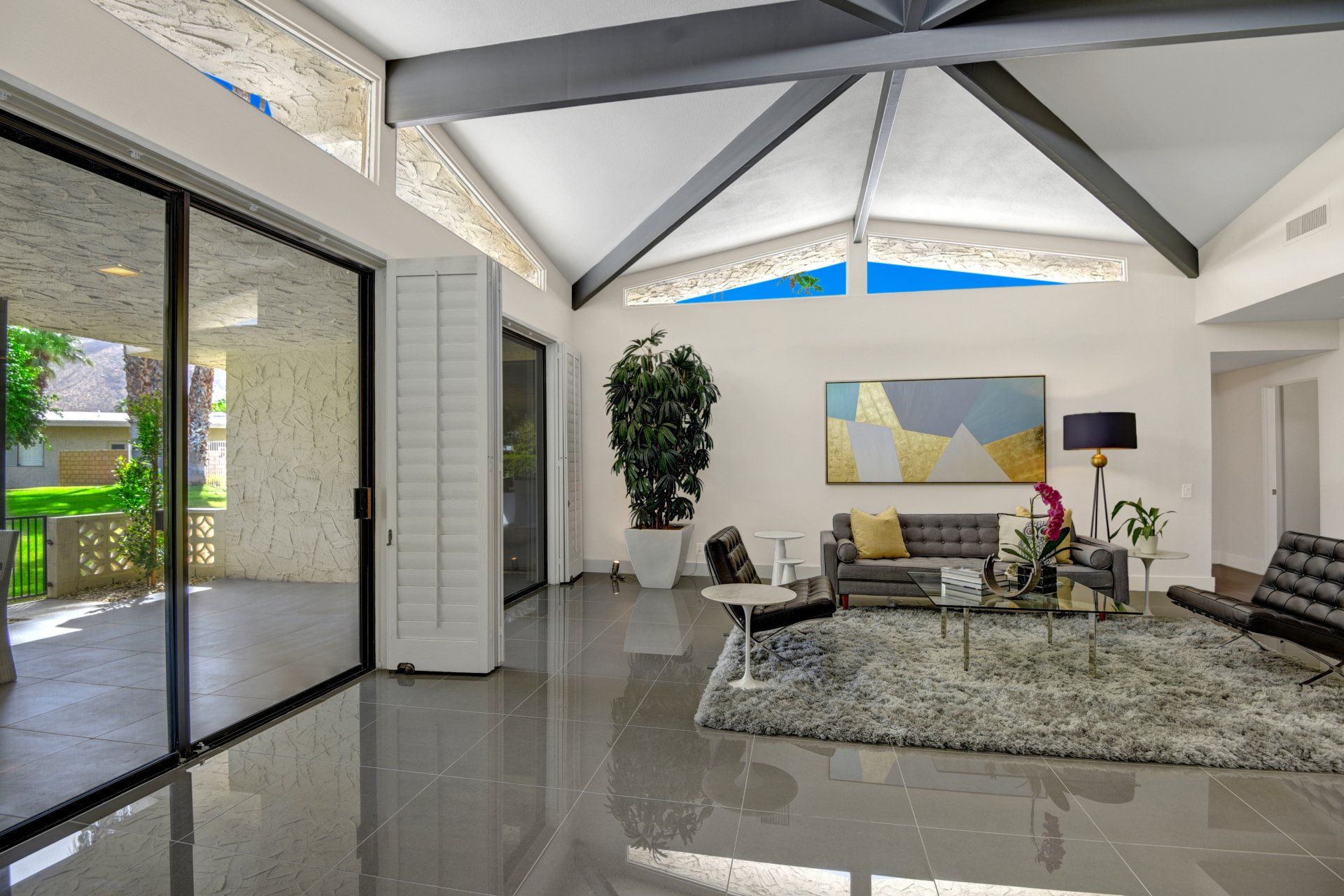 A living room with a vaulted ceiling and sliding glass doors.