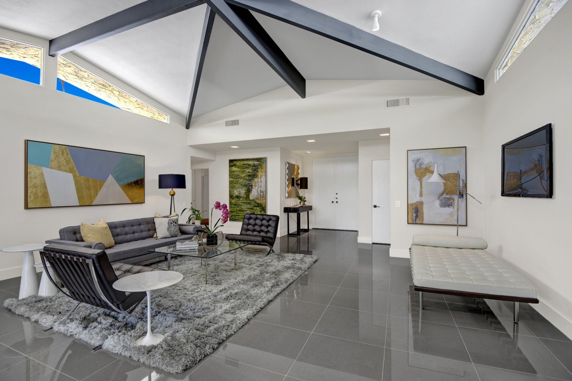 A living room with a vaulted ceiling and a couch and chairs