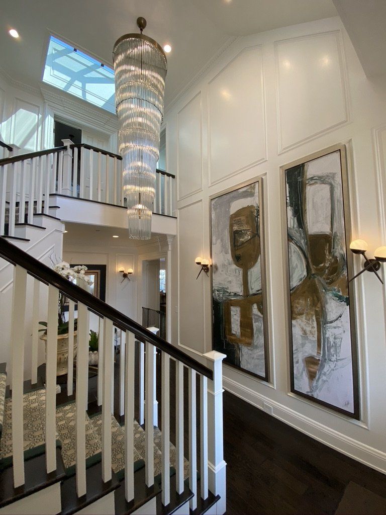 A staircase in a house with a chandelier hanging from the ceiling.