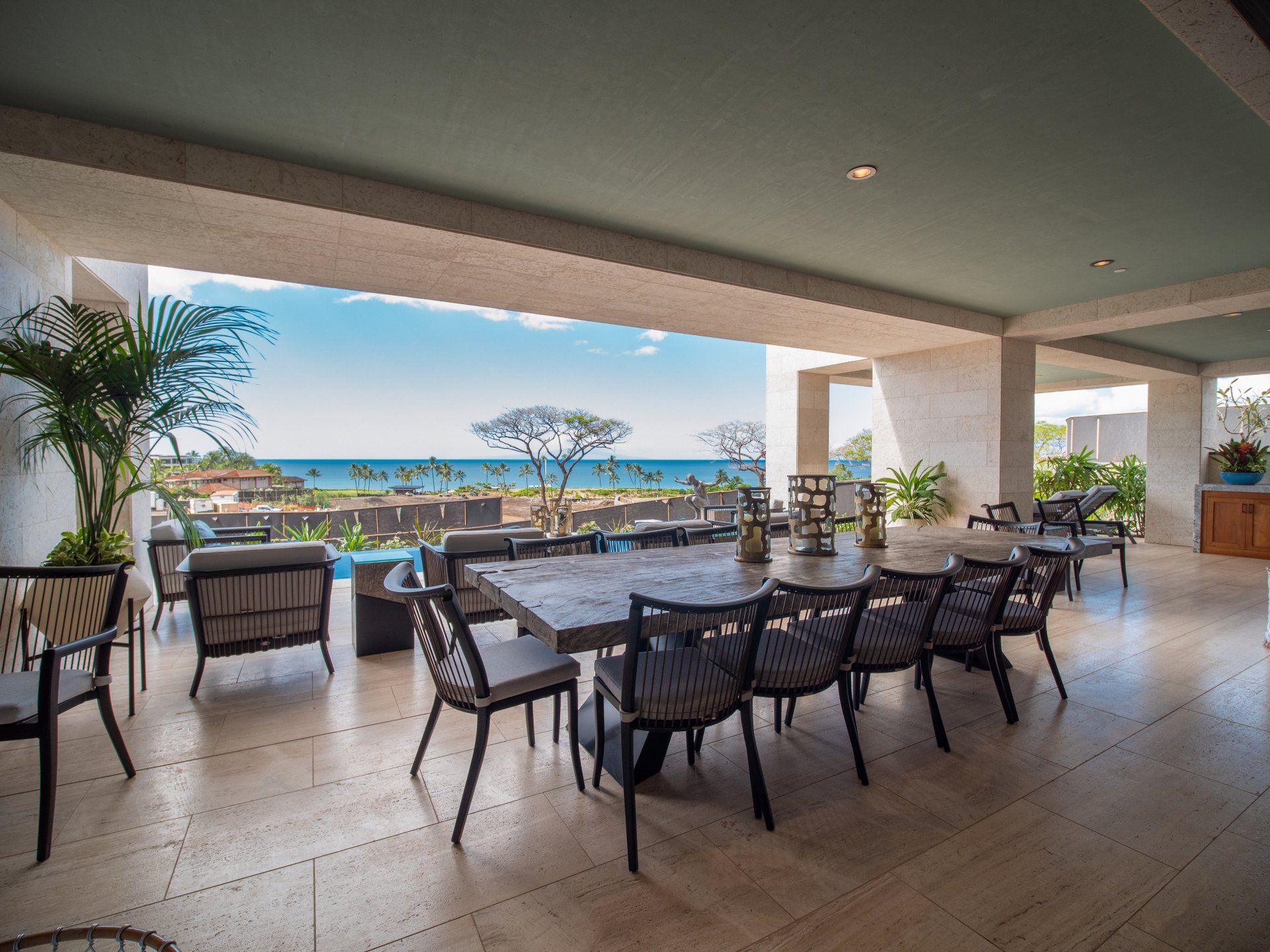A large dining room with a table and chairs and a view of the ocean.