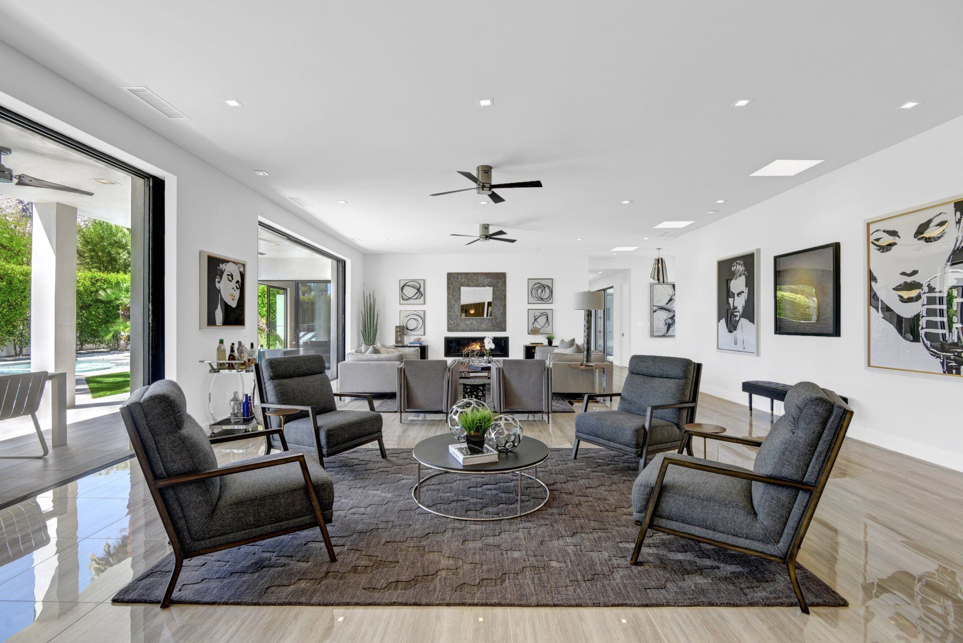 A living room with a lot of furniture and a ceiling fan.