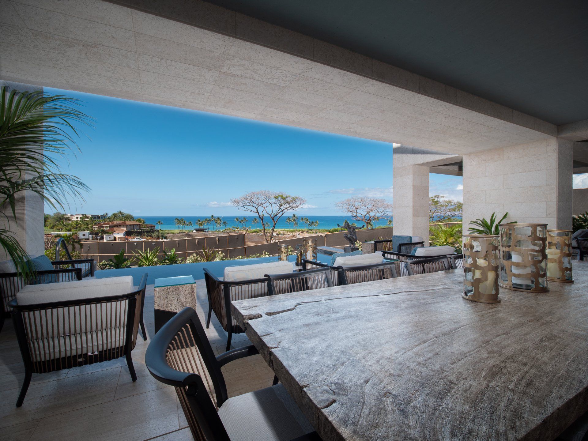 A balcony with a table and chairs overlooking the ocean