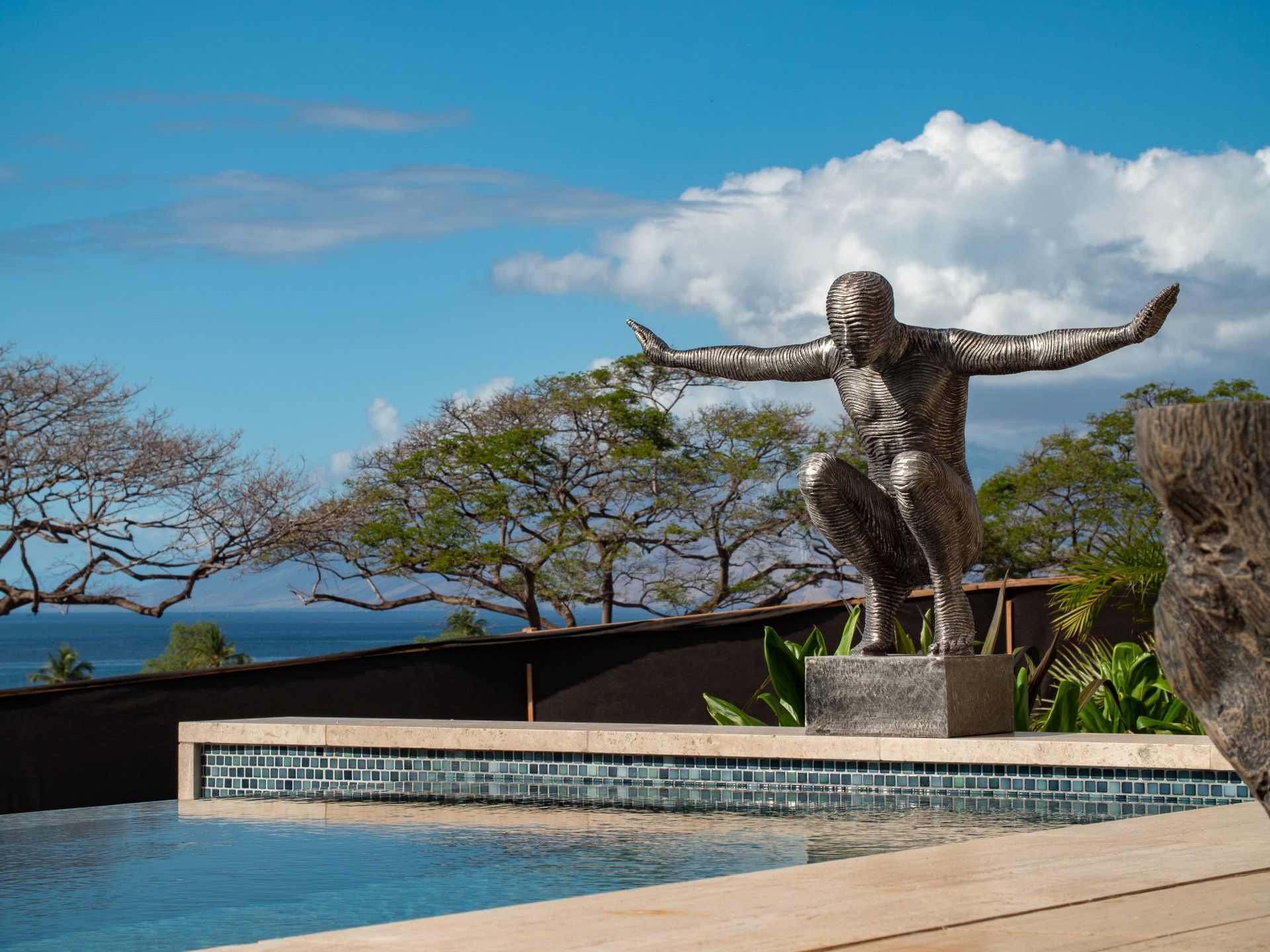 A statue of a man jumping into a pool with his arms outstretched
