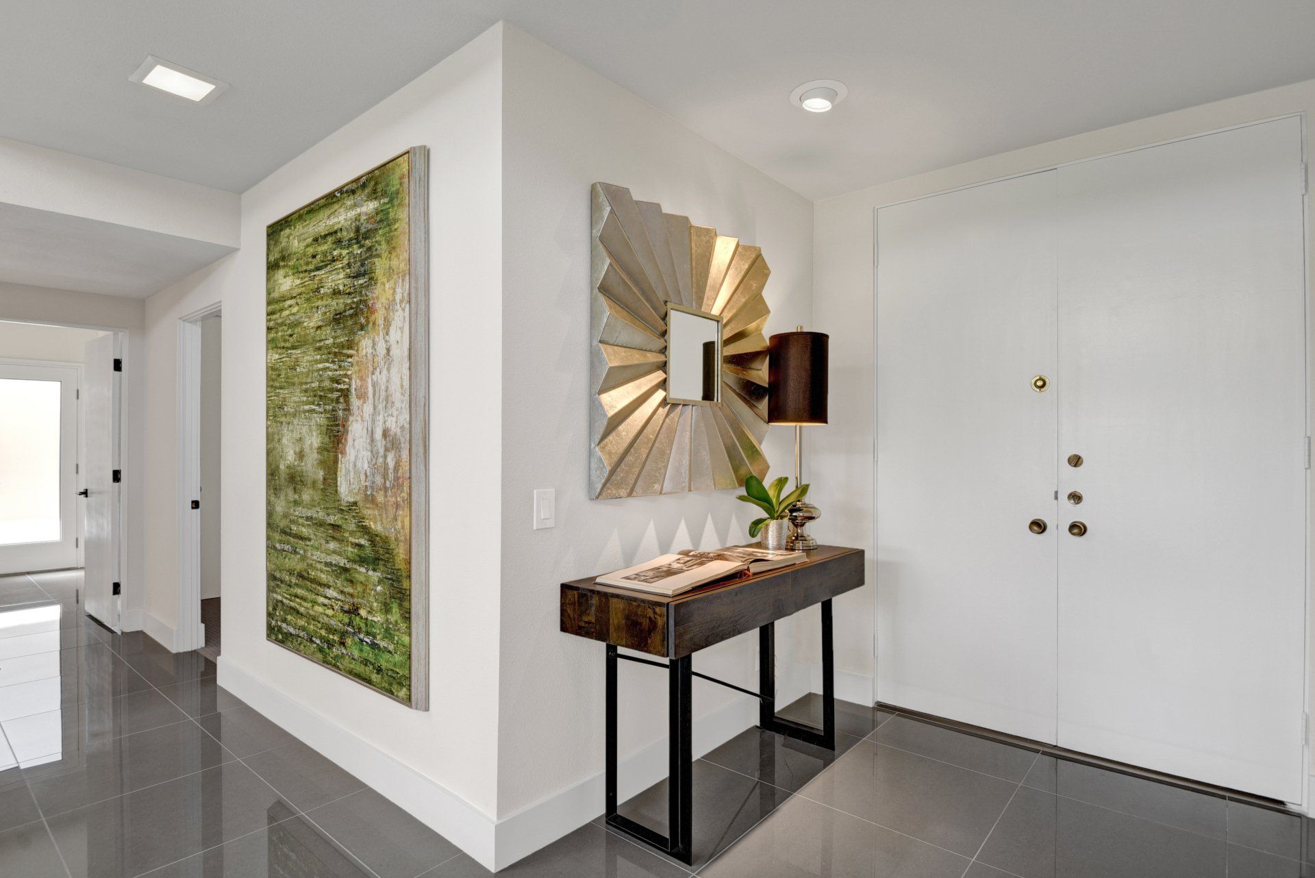 A hallway with a table and a mirror on the wall.