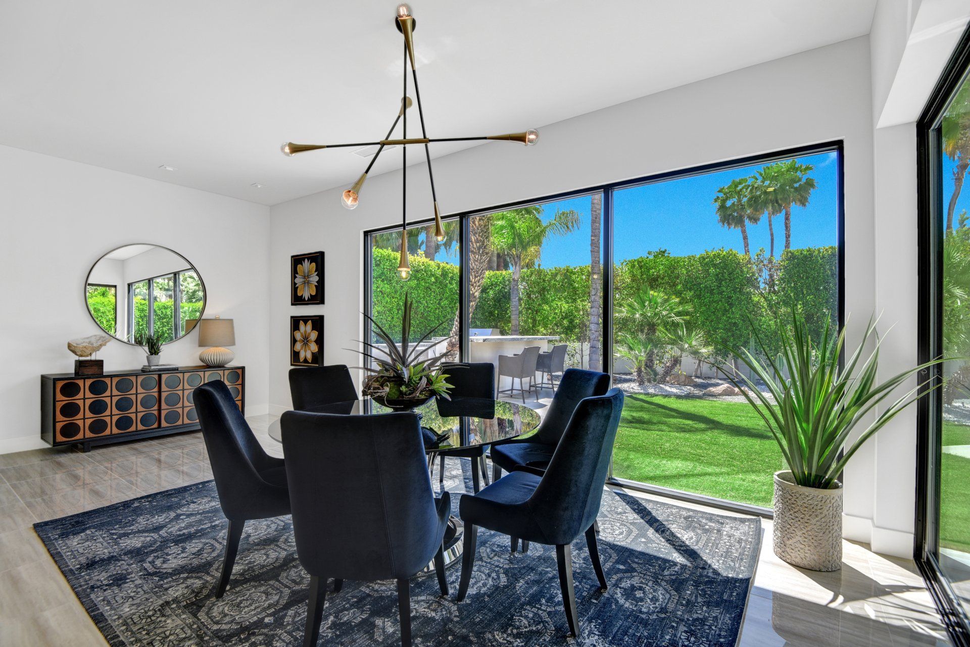 A dining room with a table and chairs and a large window.
