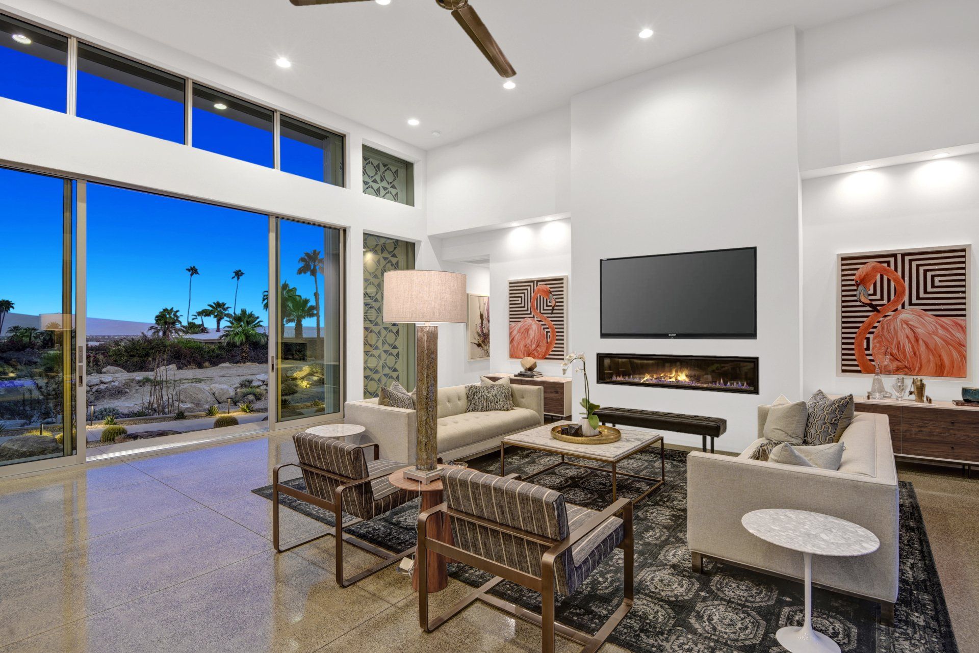 A living room with a couch , chairs , a television and a fireplace.