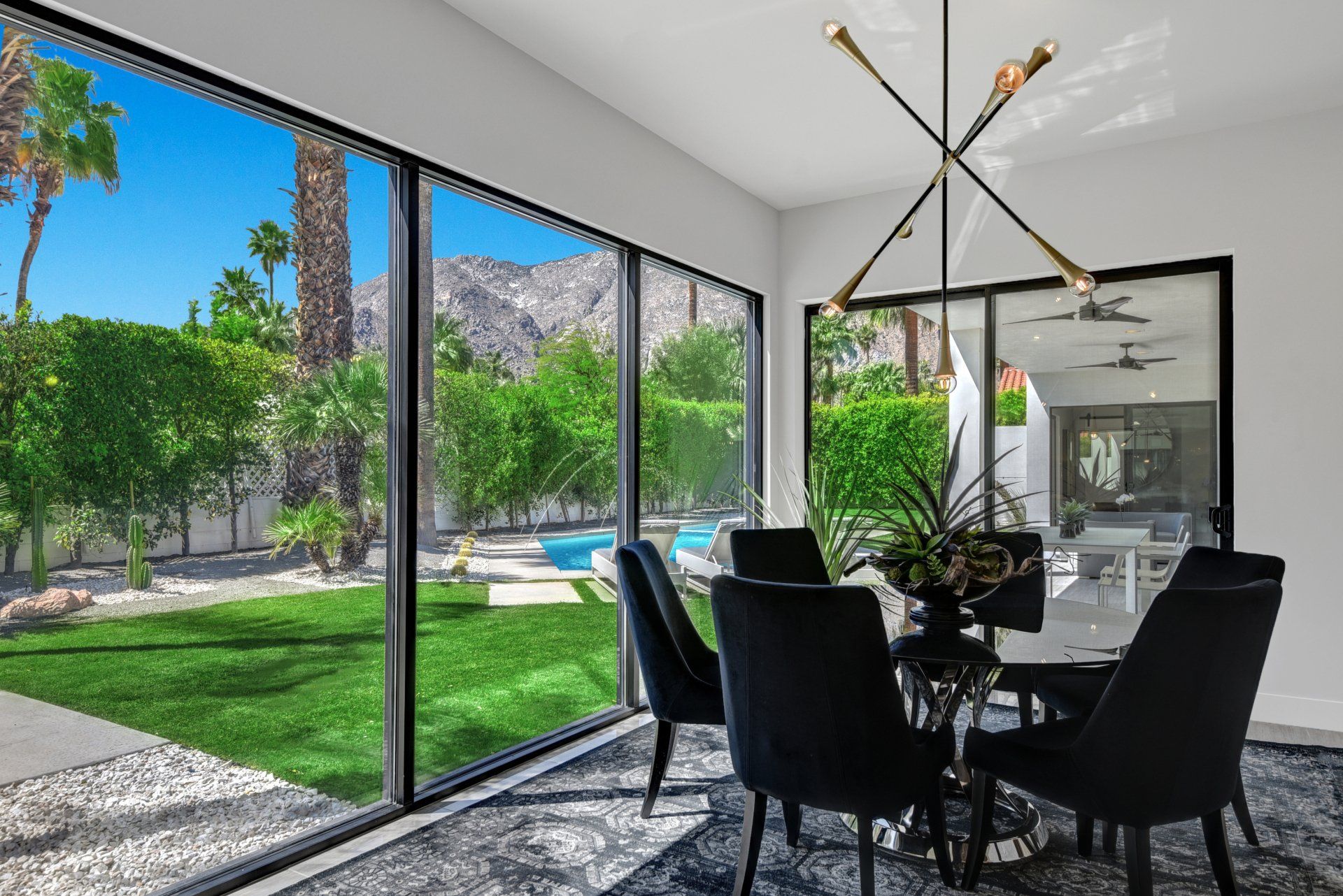 A dining room with a table and chairs and a large window.