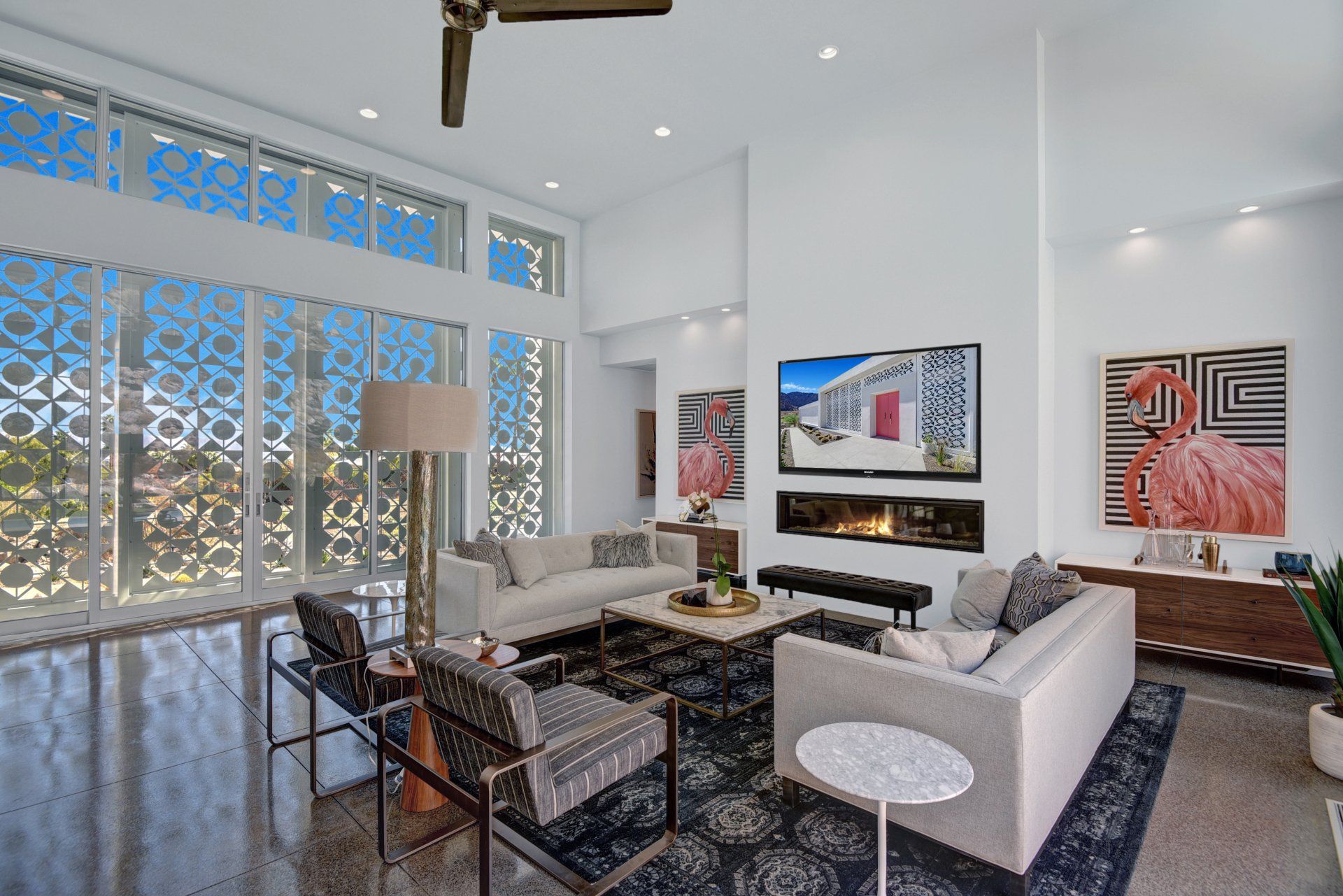 A living room with a couch , chairs , table and television.