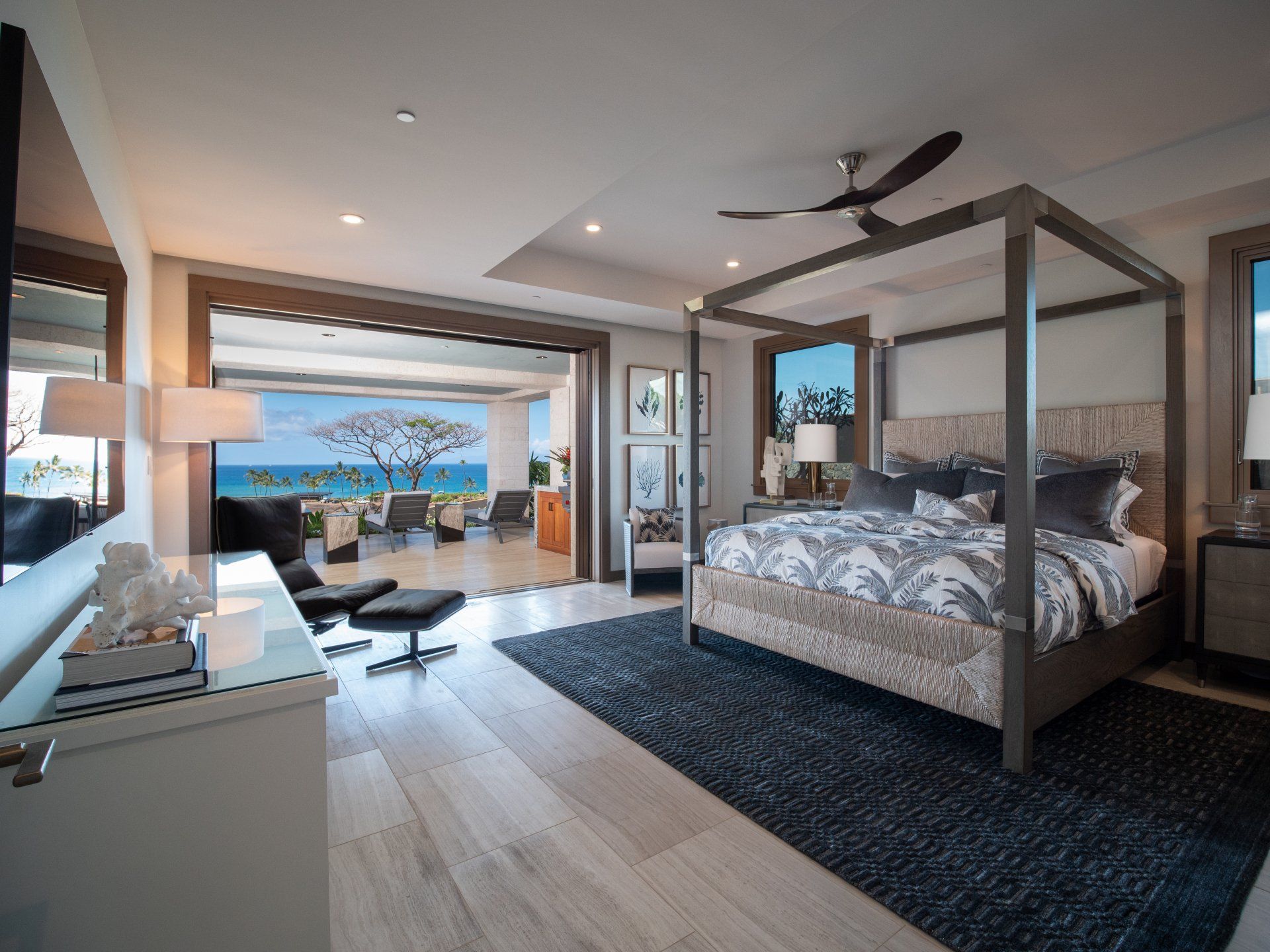 A bedroom with a canopy bed and a view of the ocean.