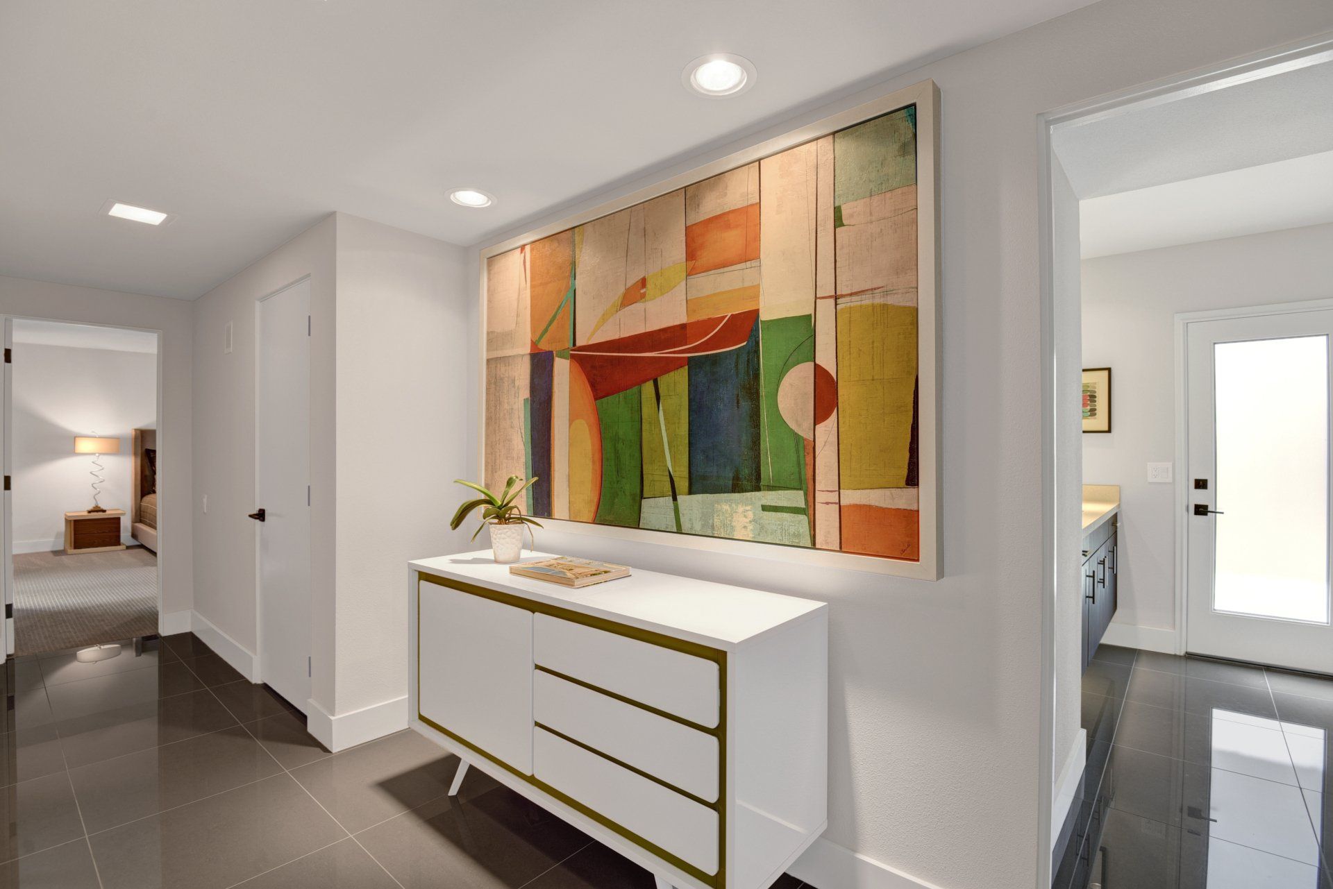 A hallway with a dresser and a large painting on the wall