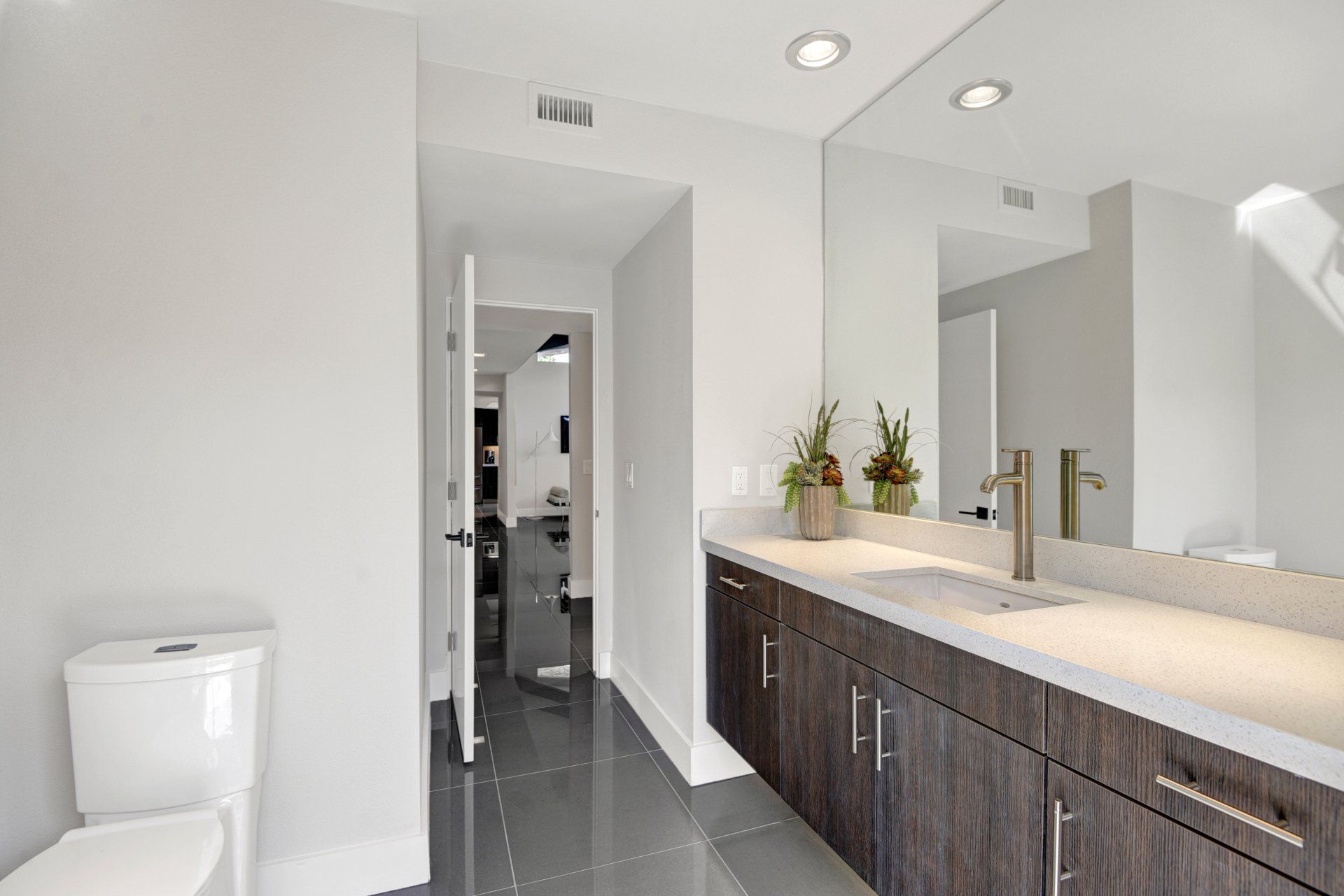 A bathroom with a toilet , sink , and mirror.
