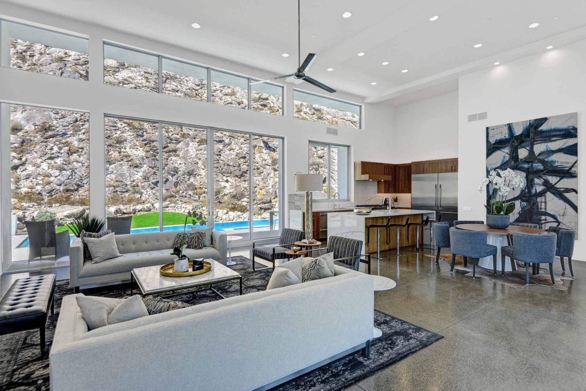 A living room with a couch , table , chairs and a ceiling fan.