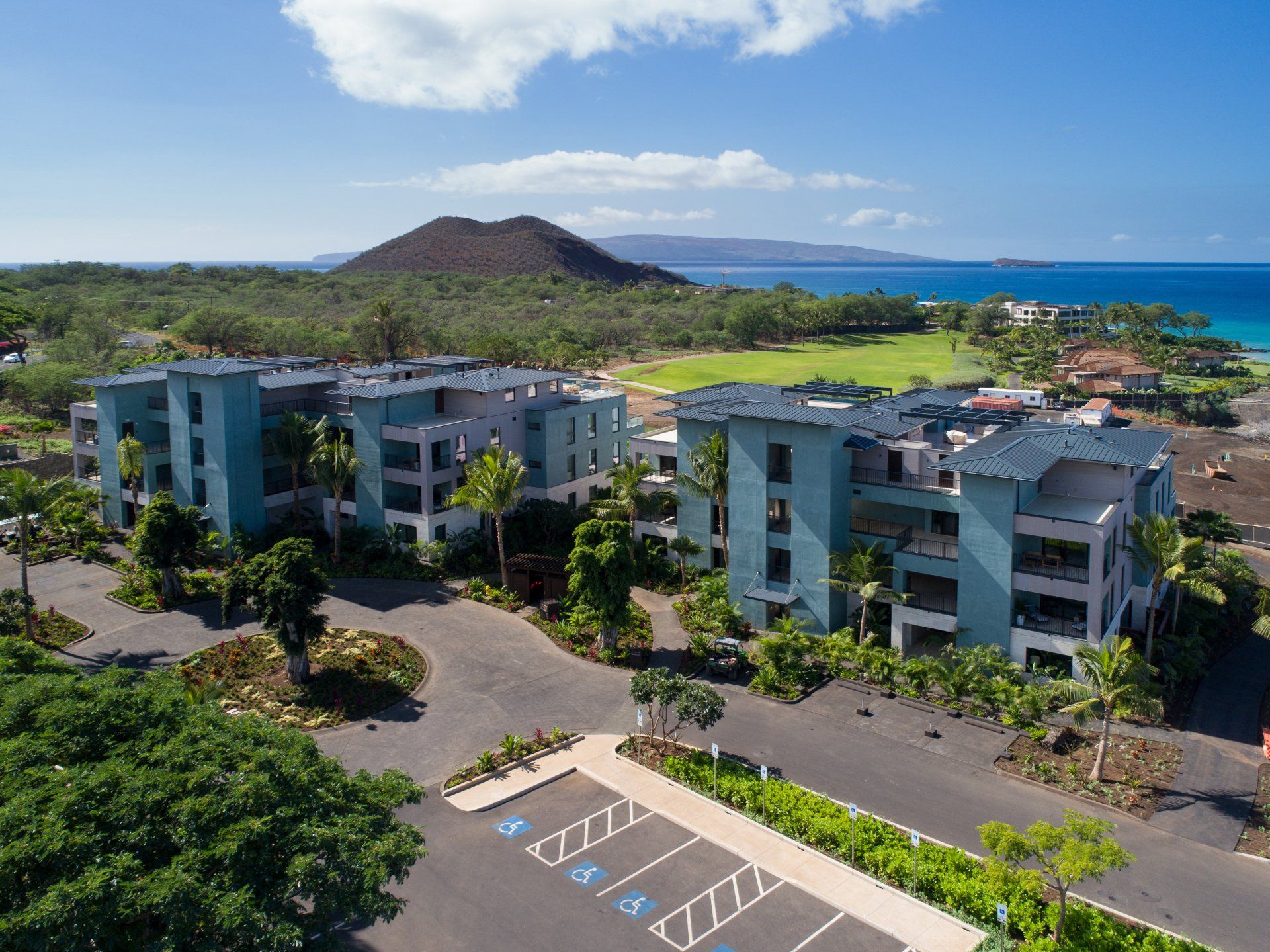 An aerial view of a large building with a parking lot in front of it.
