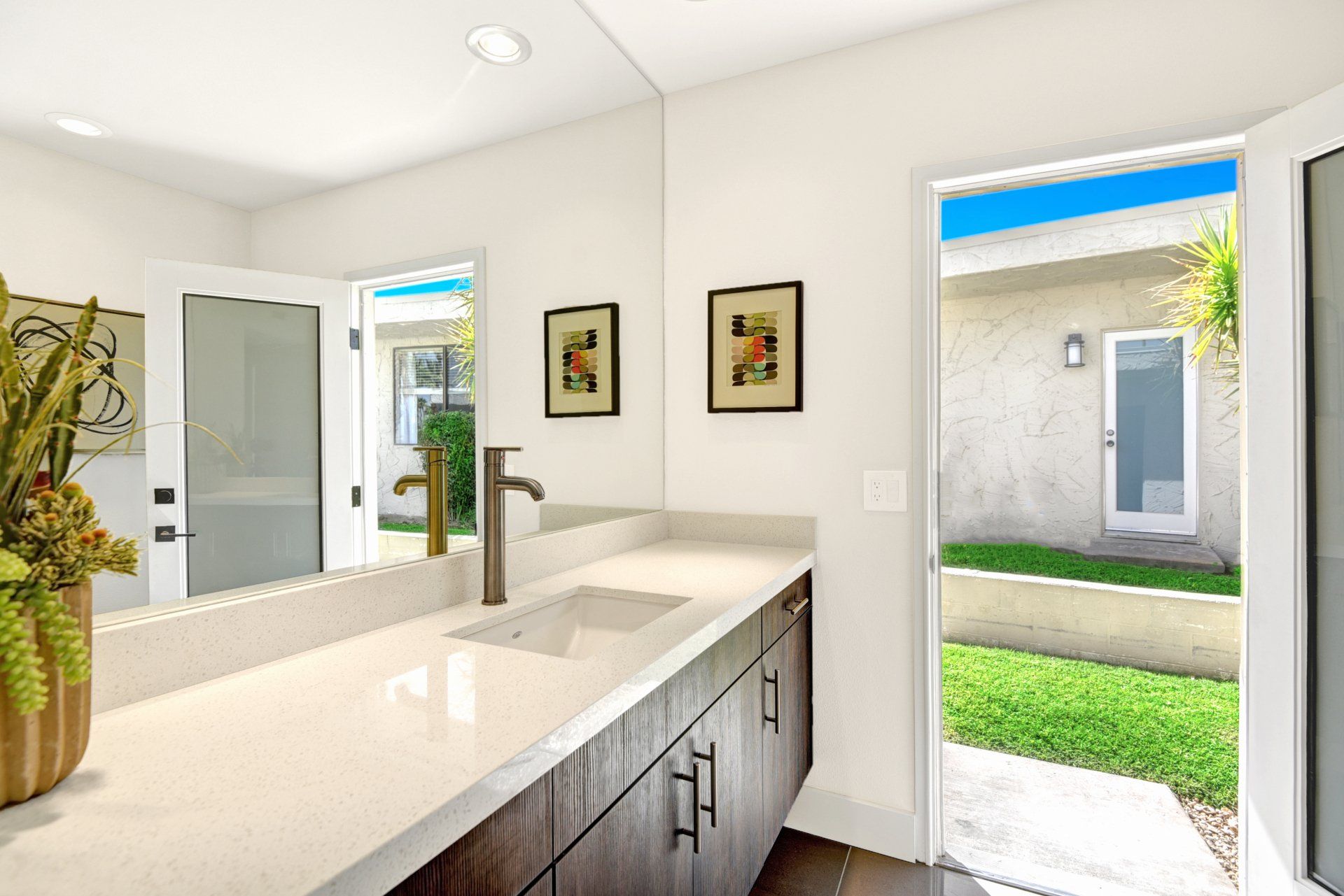 A bathroom with a sink and a large mirror.