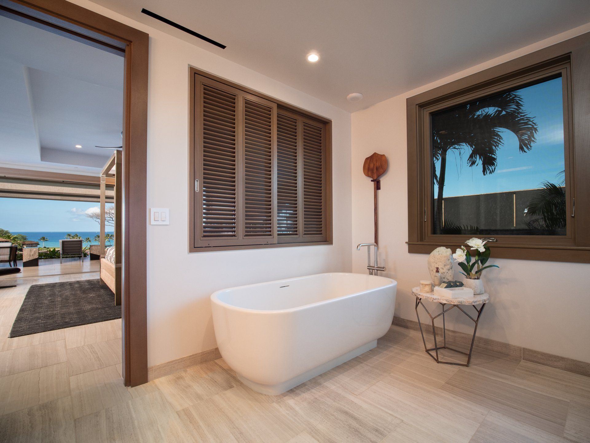 A bathroom with a tub and a window with shutters