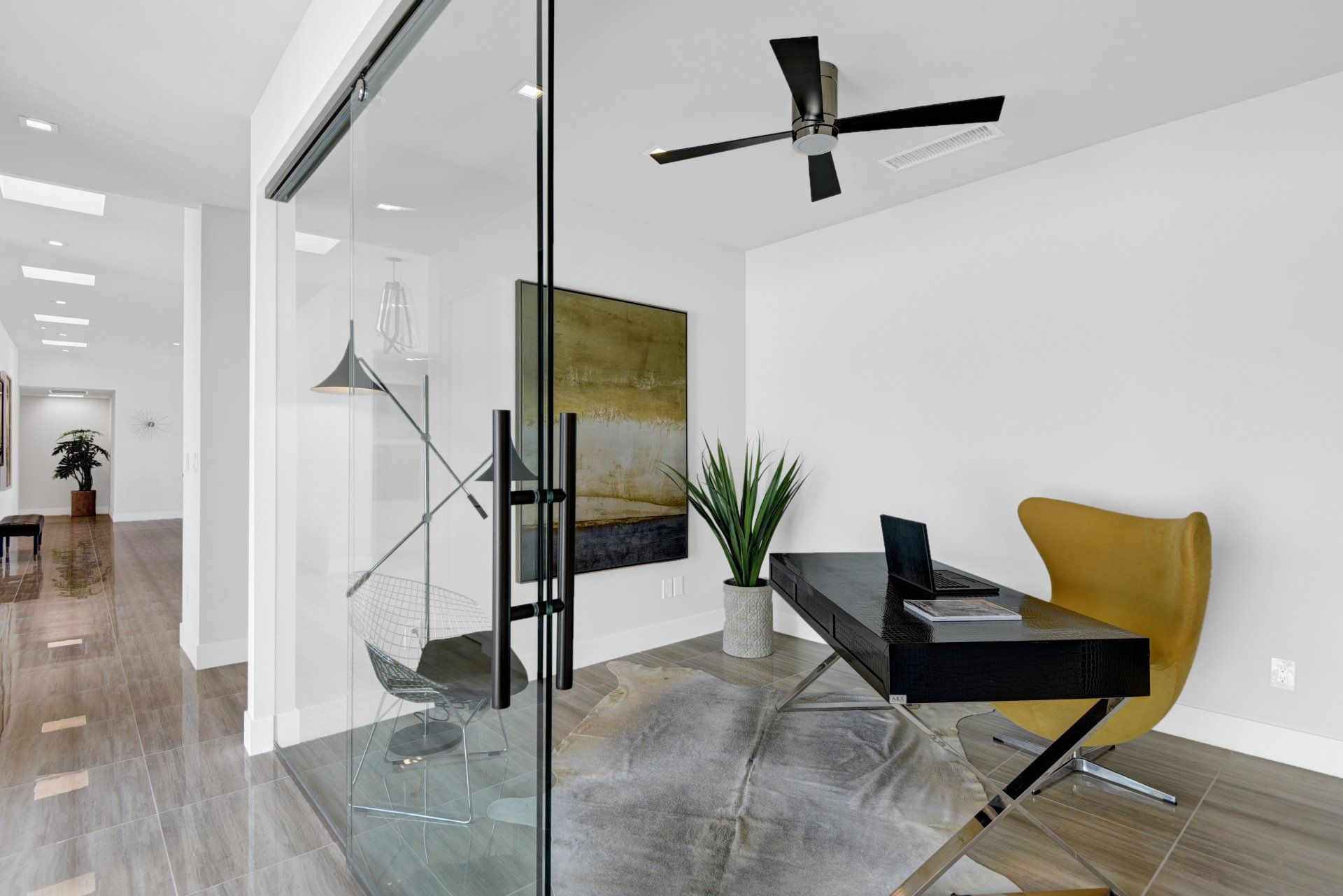 A home office with a desk , chair , and ceiling fan.