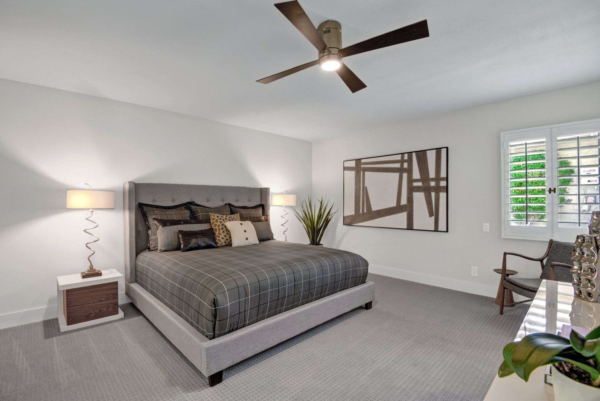 A bedroom with a king size bed and a ceiling fan.
