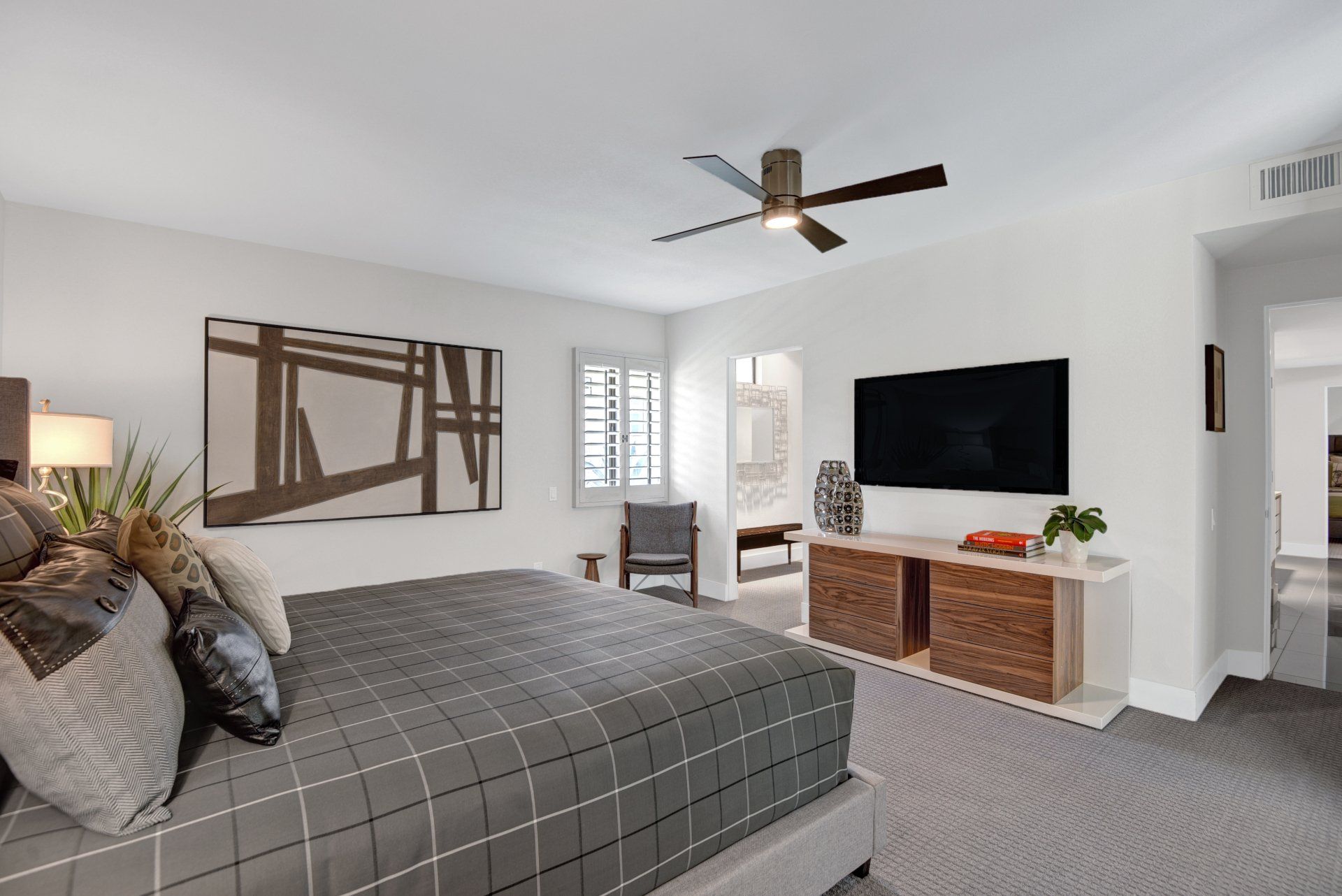A bedroom with a large bed and a flat screen tv on the wall.