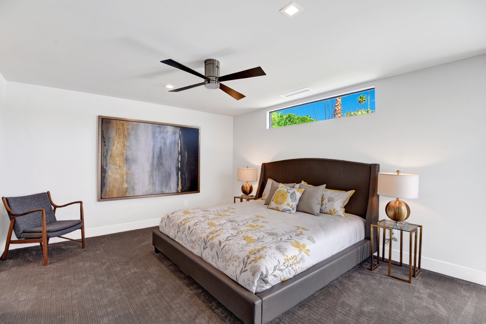 A bedroom with a large bed and a ceiling fan.