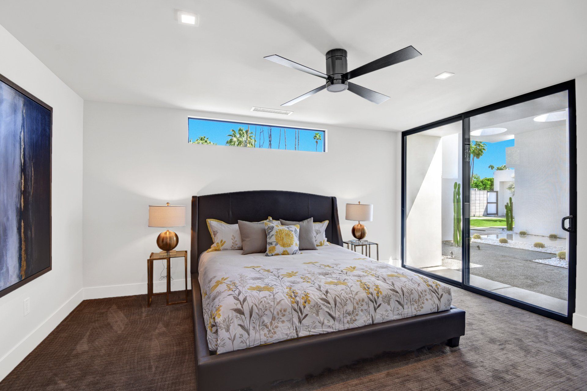 A bedroom with a large bed and a ceiling fan