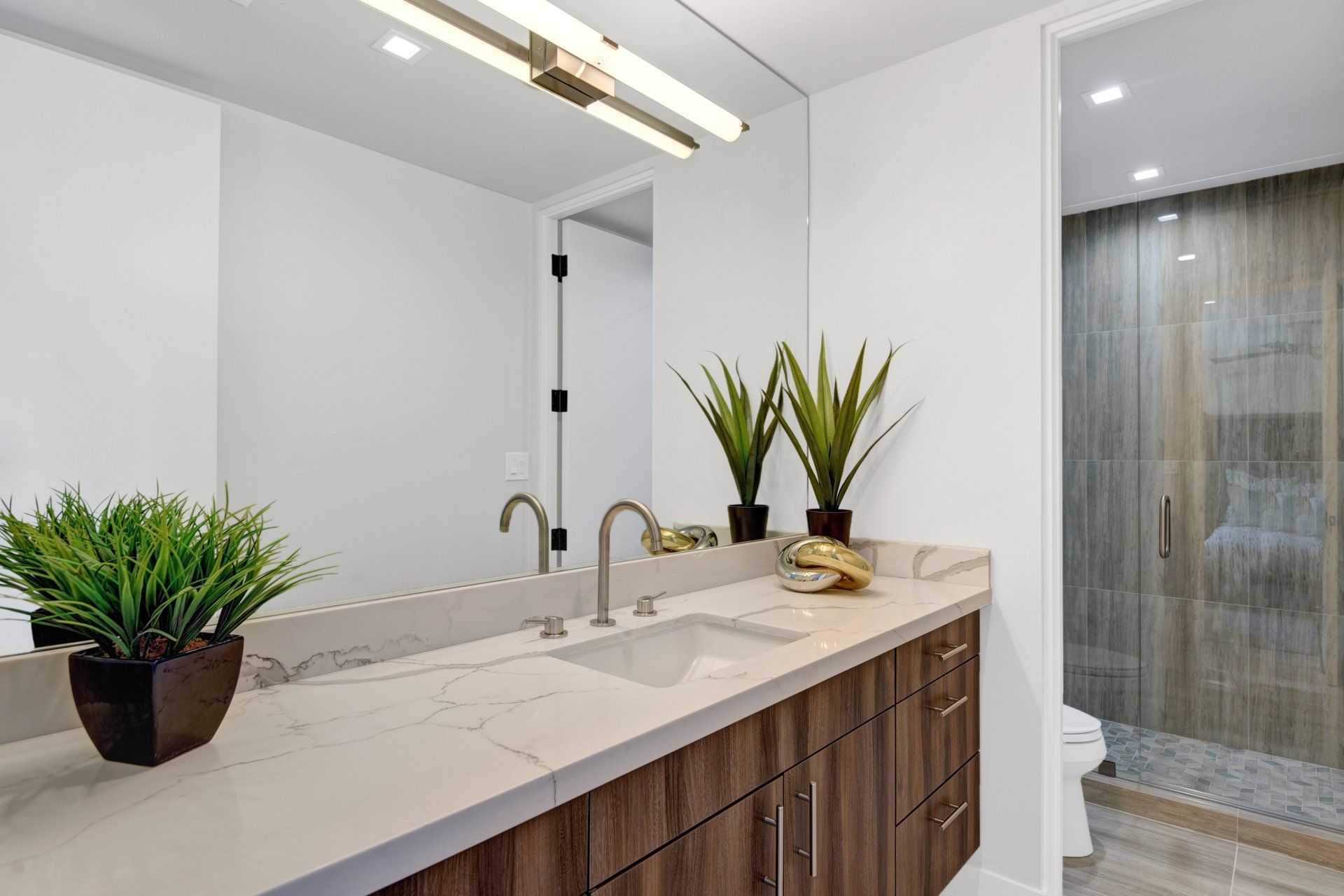 A bathroom with a sink , mirror and toilet.
