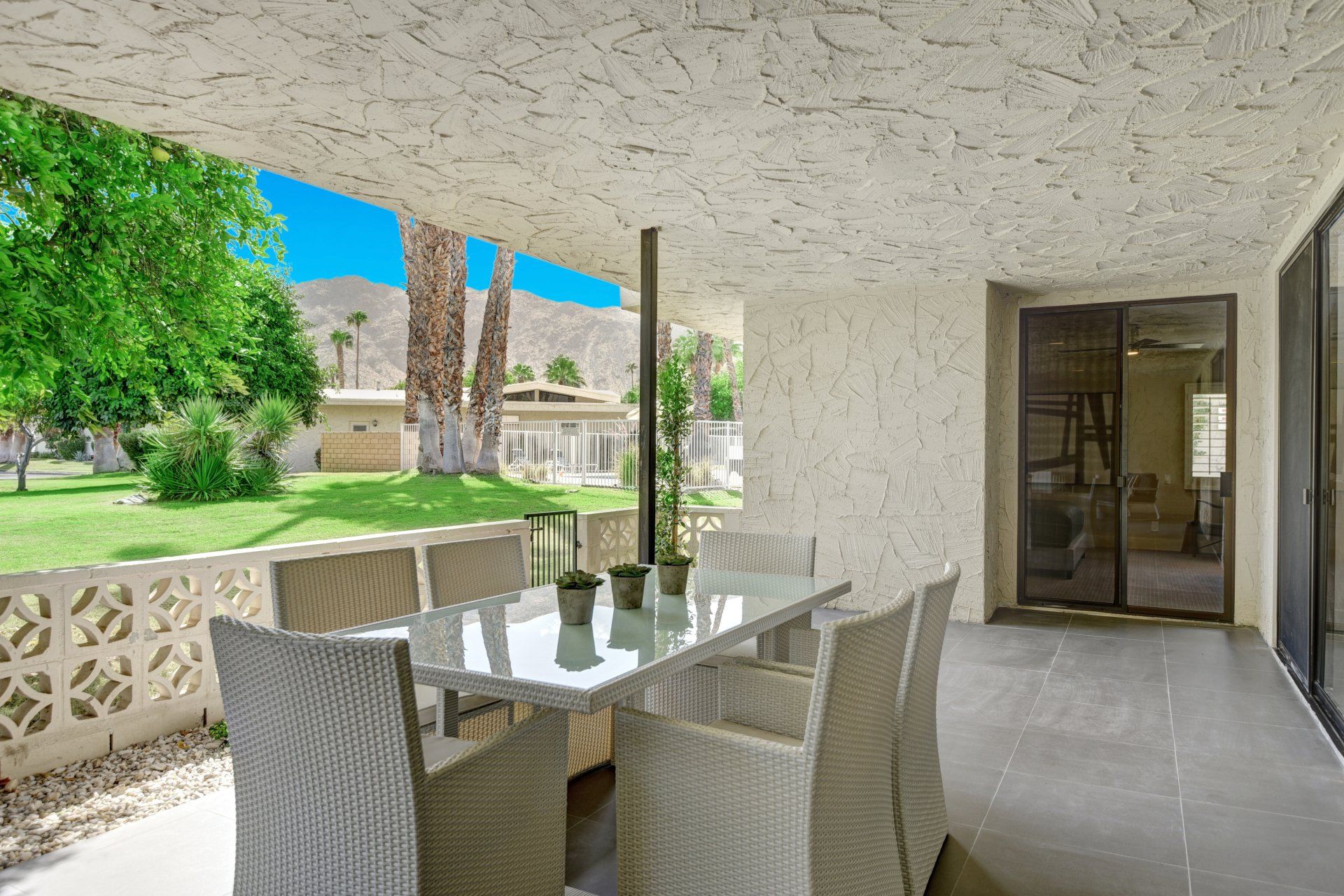 There is a patio with a table and chairs on it.