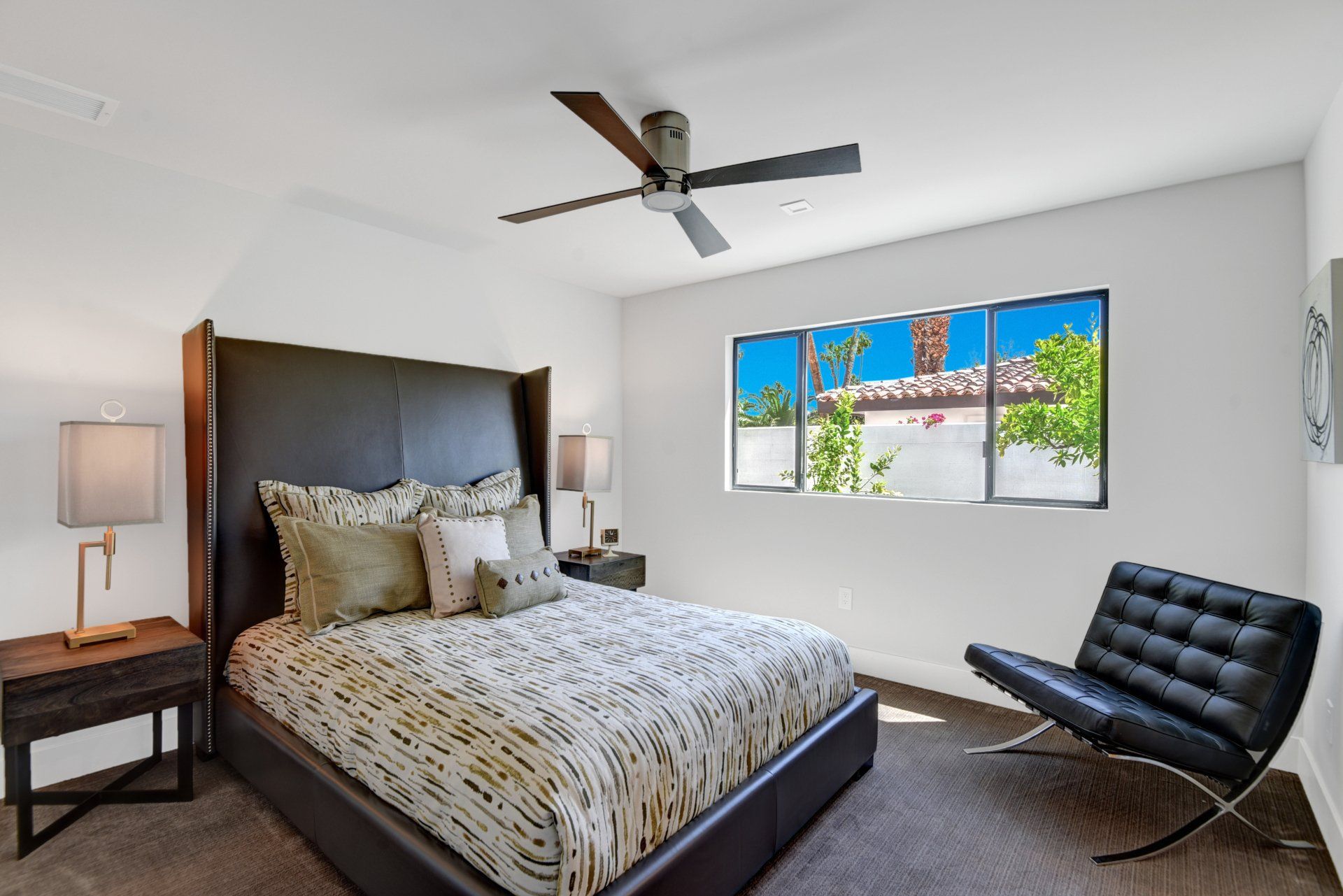 A bedroom with a large bed and a ceiling fan