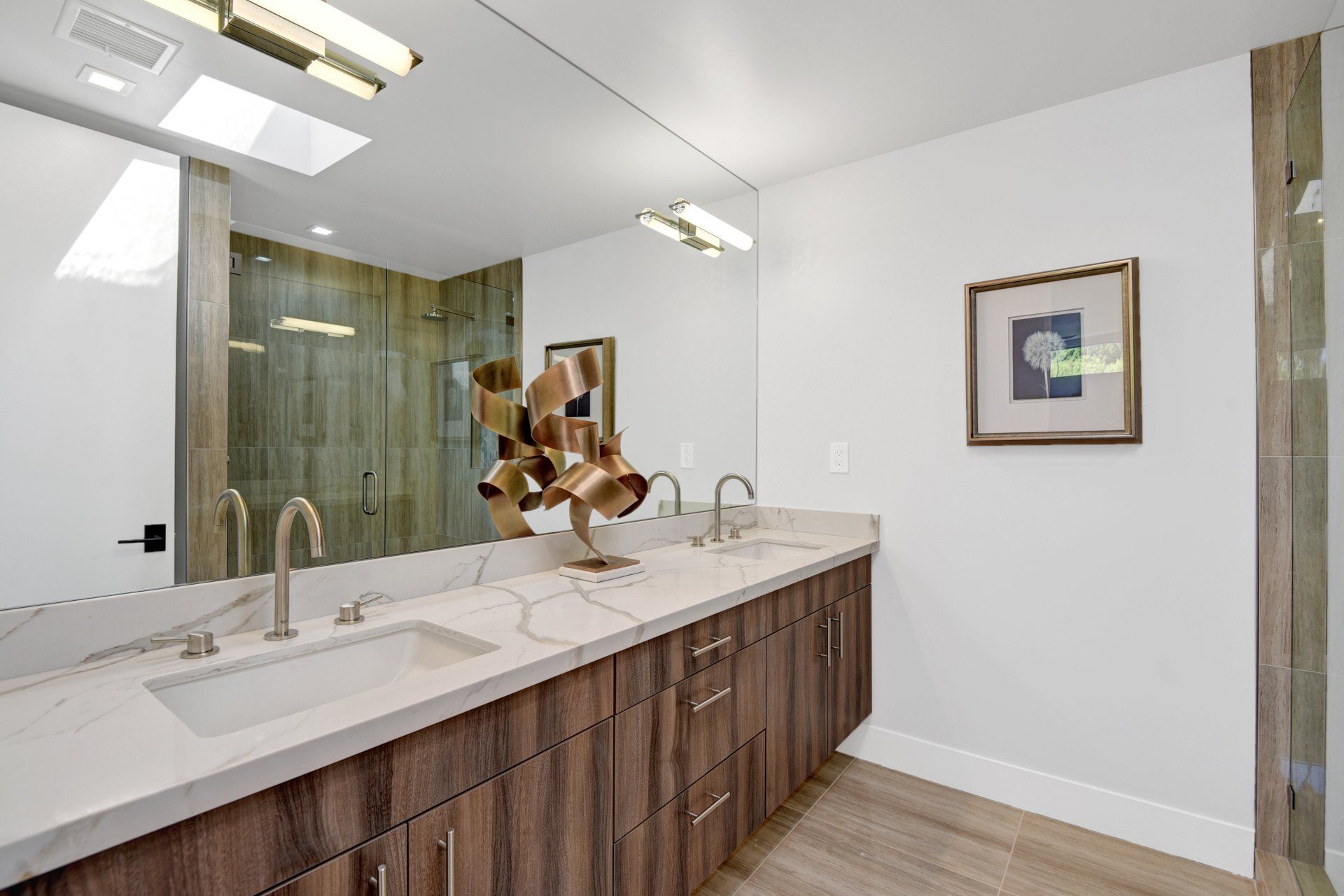 A bathroom with two sinks and a large mirror.
