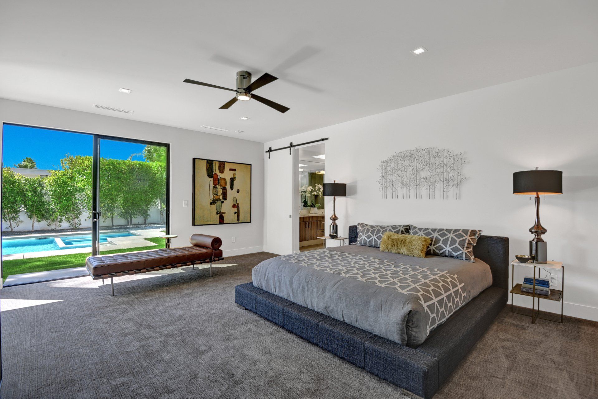 A bedroom with a large bed and a ceiling fan