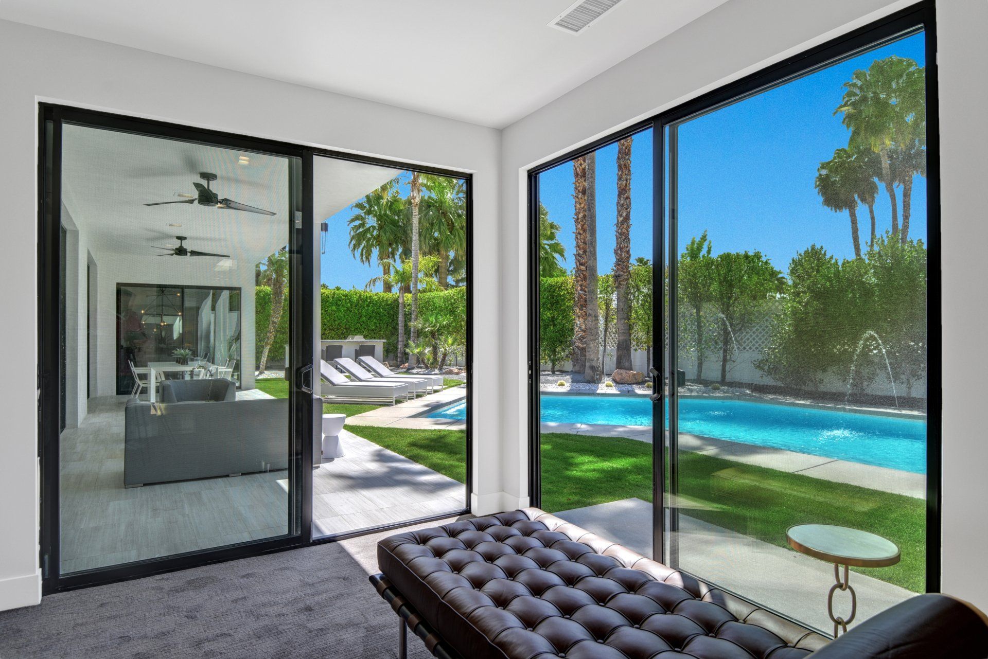 A living room with sliding glass doors leading to a pool.