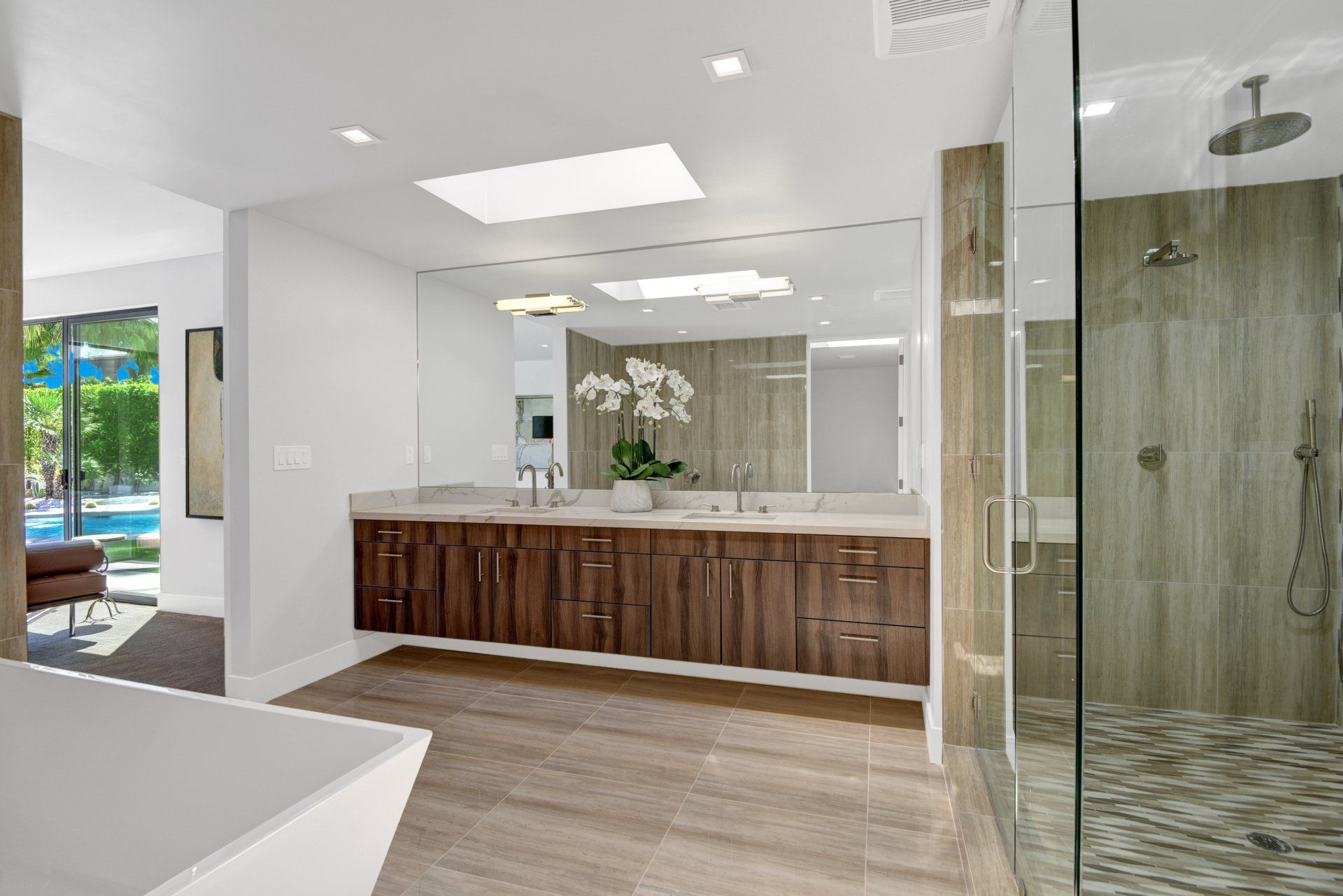 A bathroom with two sinks and a walk in shower.