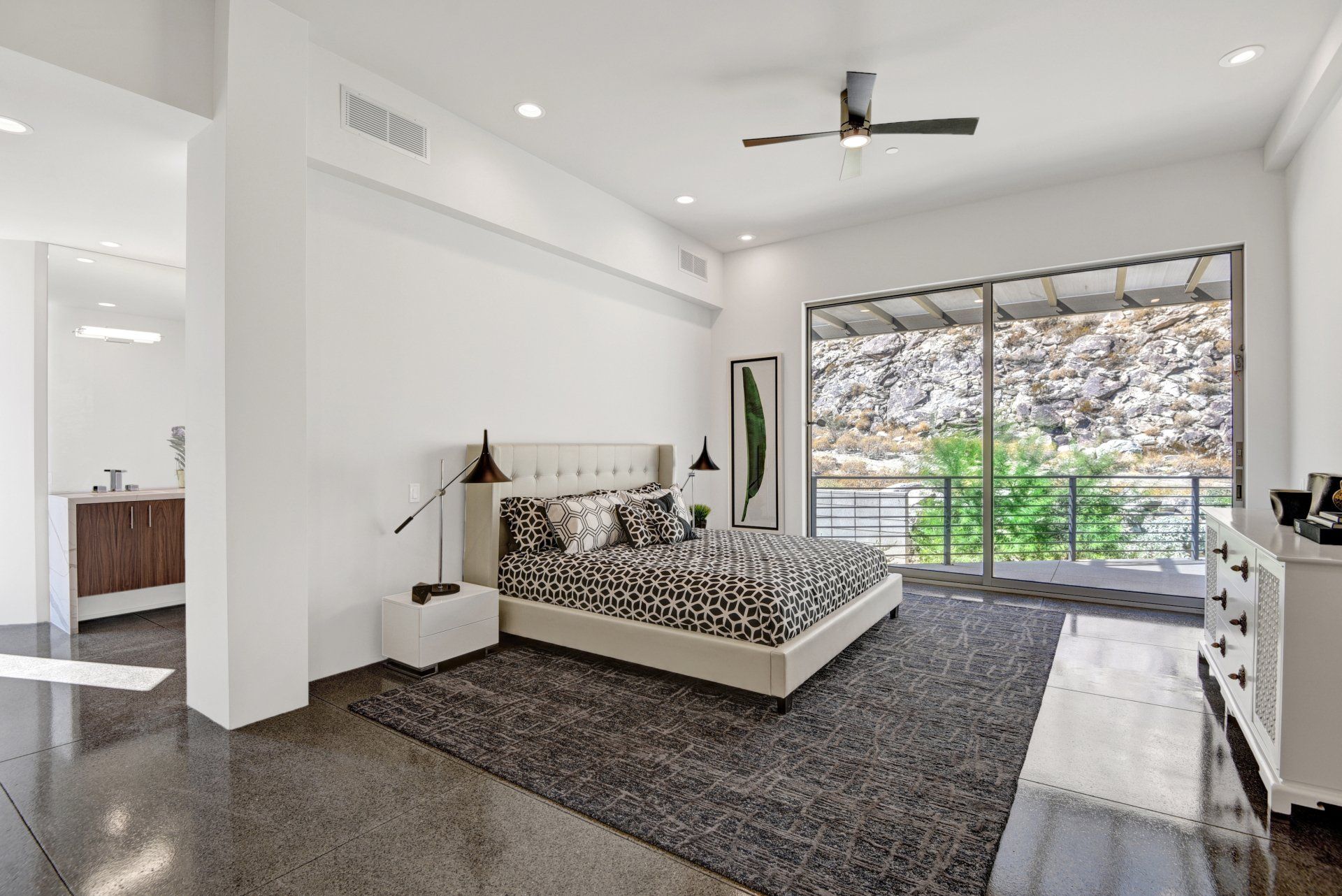 A bedroom with a large bed and a ceiling fan.