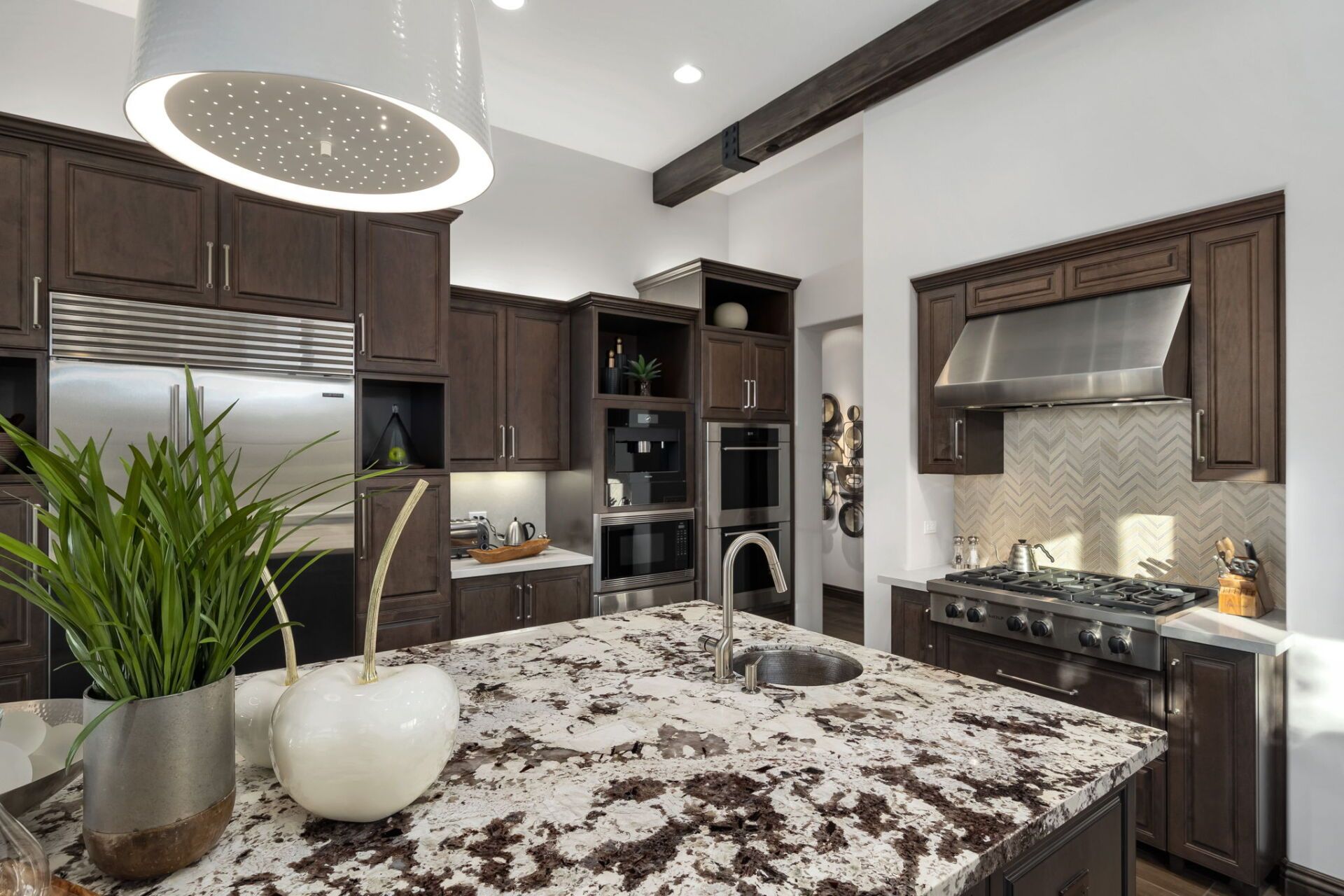 A kitchen with granite counter tops and stainless steel appliances.
