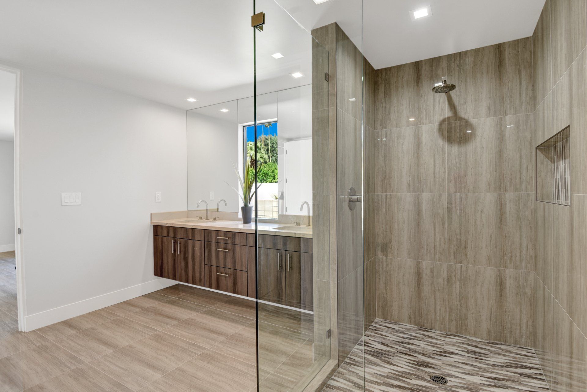A bathroom with a walk in shower and two sinks.