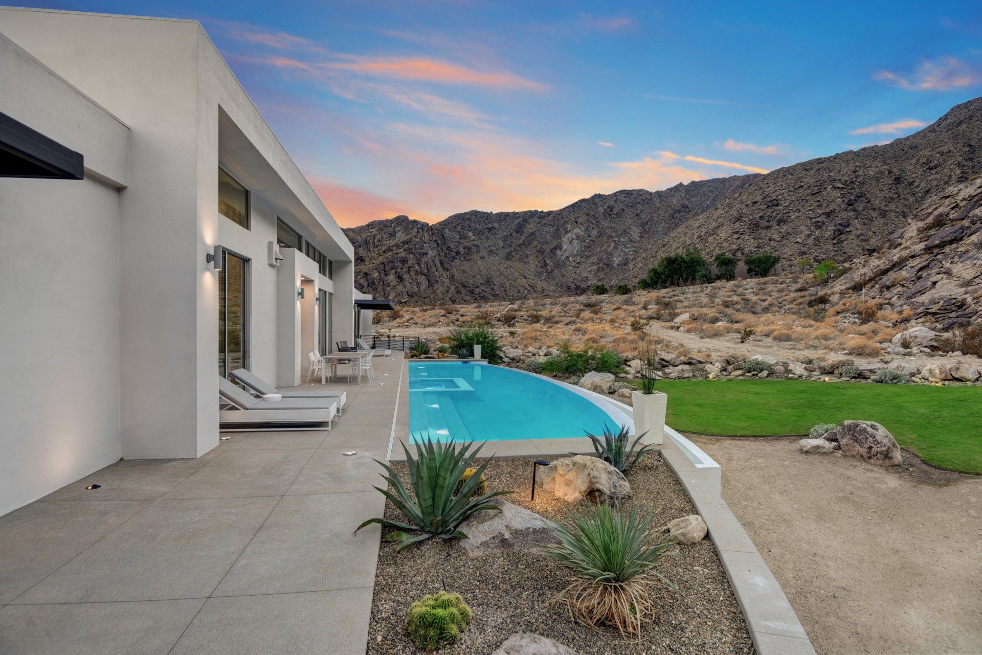 There is a large swimming pool in the backyard of a house.