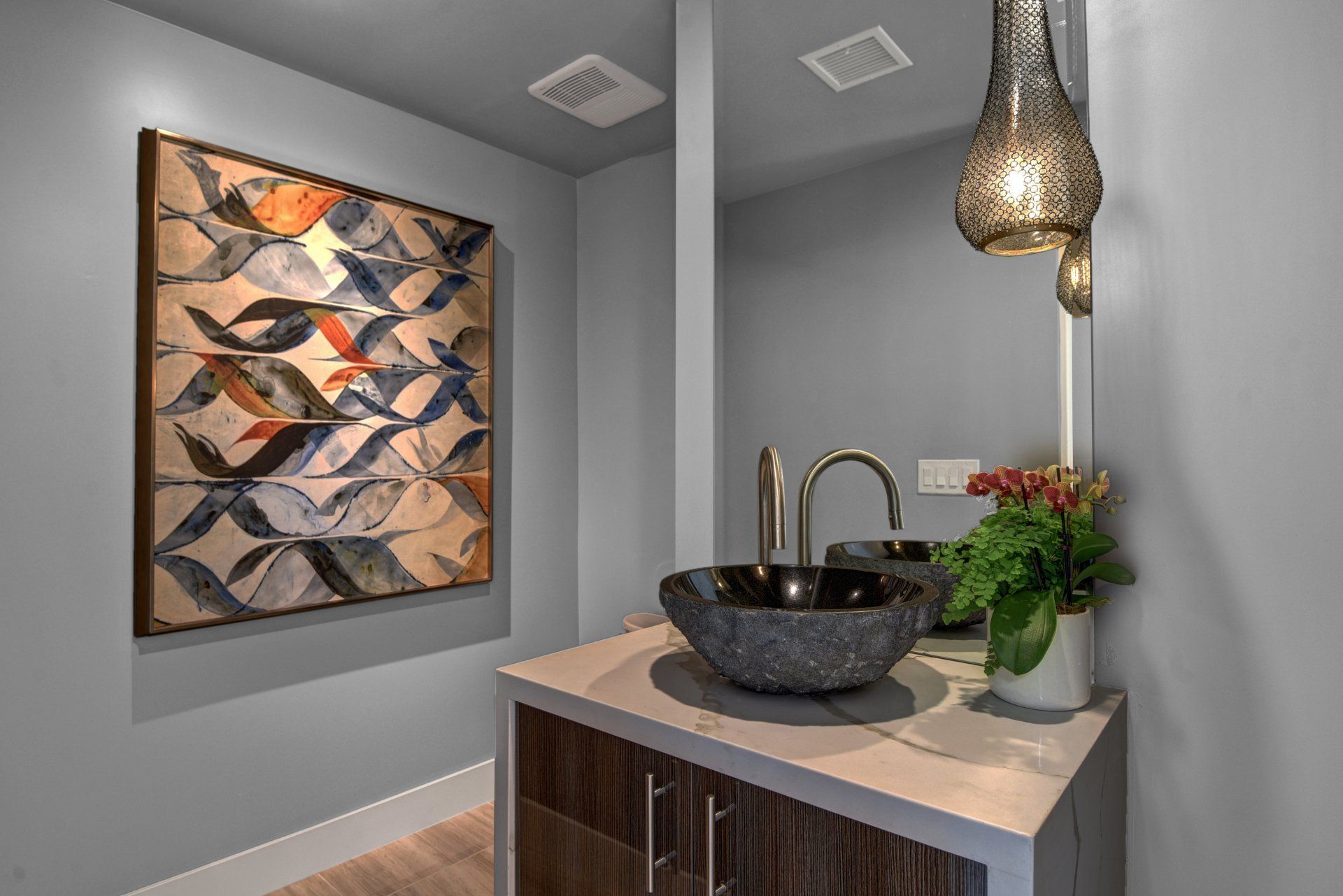 A bathroom with a sink and a painting on the wall.