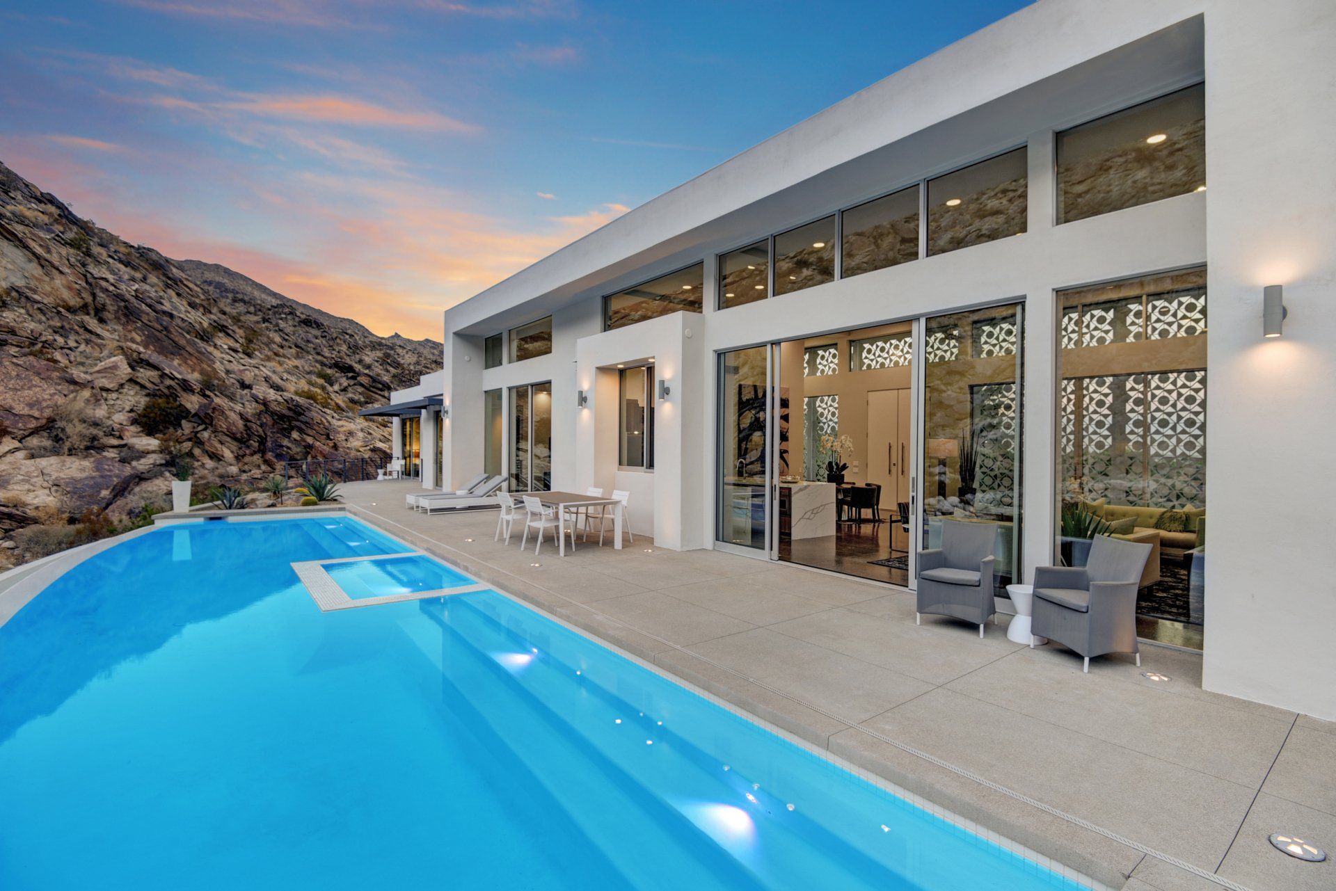 A large white house with a large swimming pool in front of it.